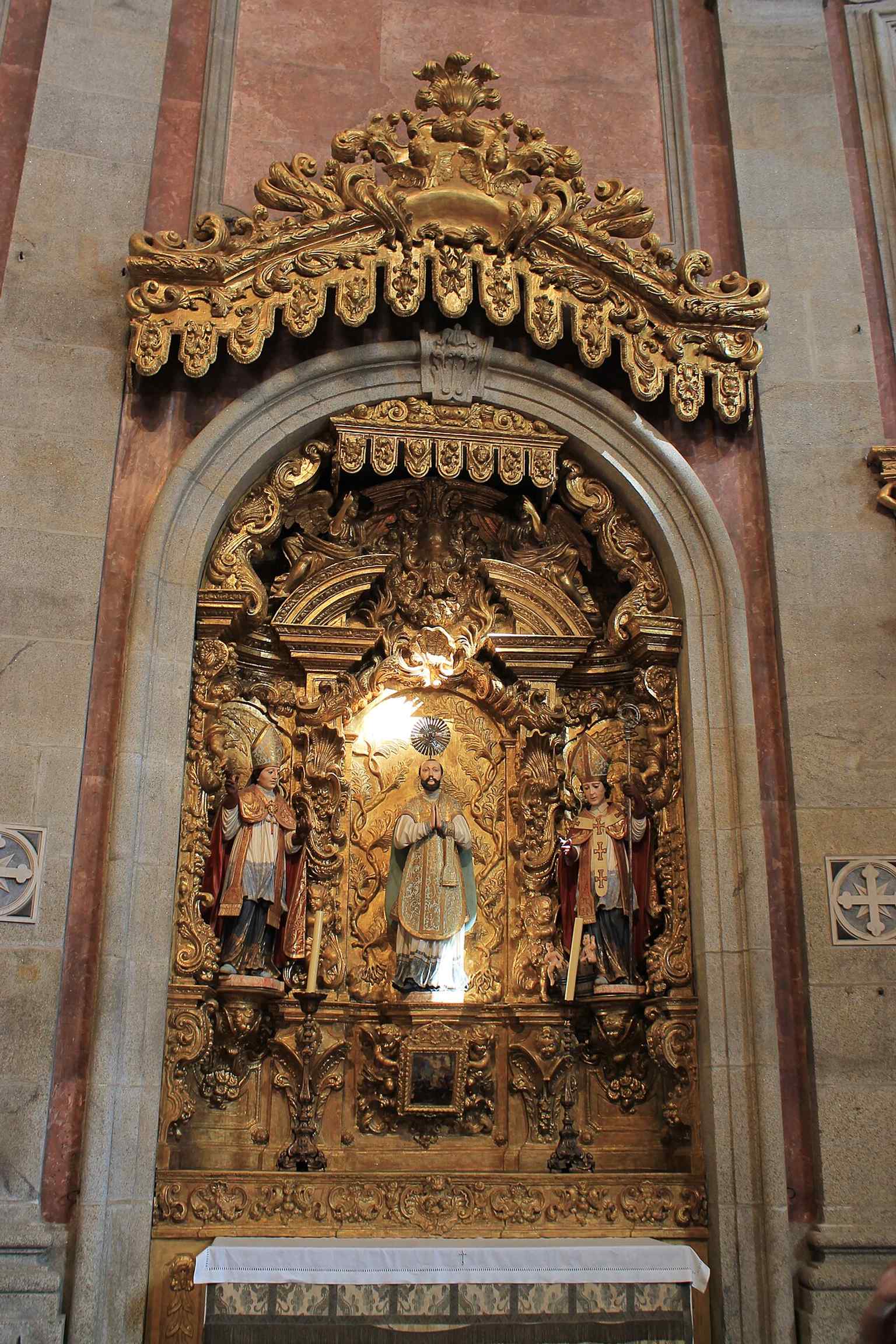 An interior view toward the altar area, where the main chapel’s polychromed marble altarpiece stands out.