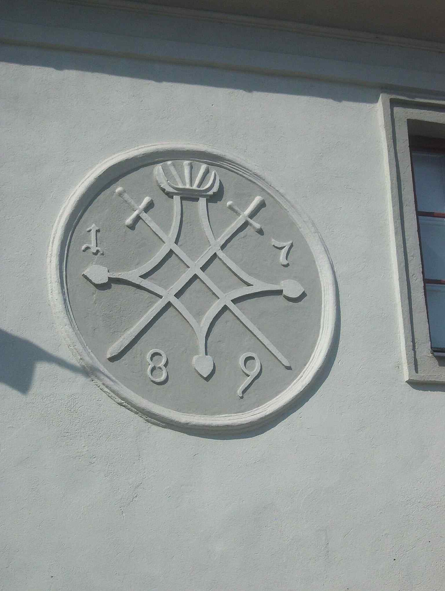 A close-up of the Sibiu coat of arms displayed on the Casa Artelor, a historical monument documented since 1370.