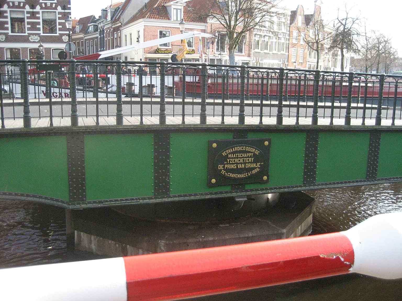 An opened Melkbrug with a boat passing through, reflecting the bridge’s function as a managed gateway for river traffic.