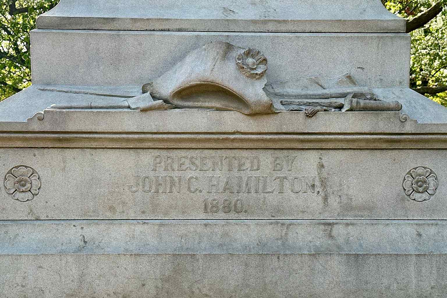 A wider modern photograph of the Hamilton statue in Central Park, showing the full outdoor monument that honors the founding father in granite.