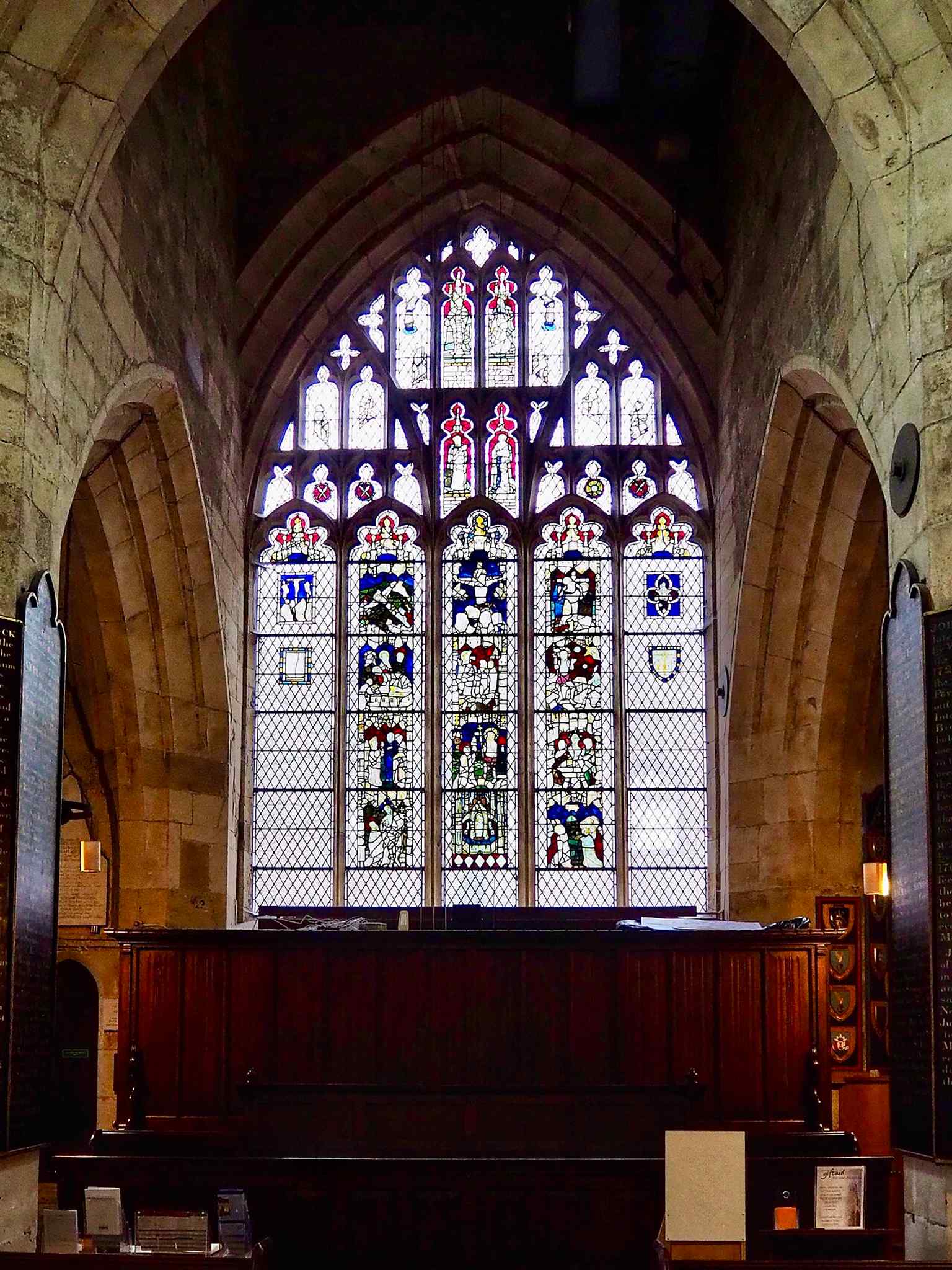 Stained glass in the church, reflecting the Victorian restoration campaign and later memorial glazing.