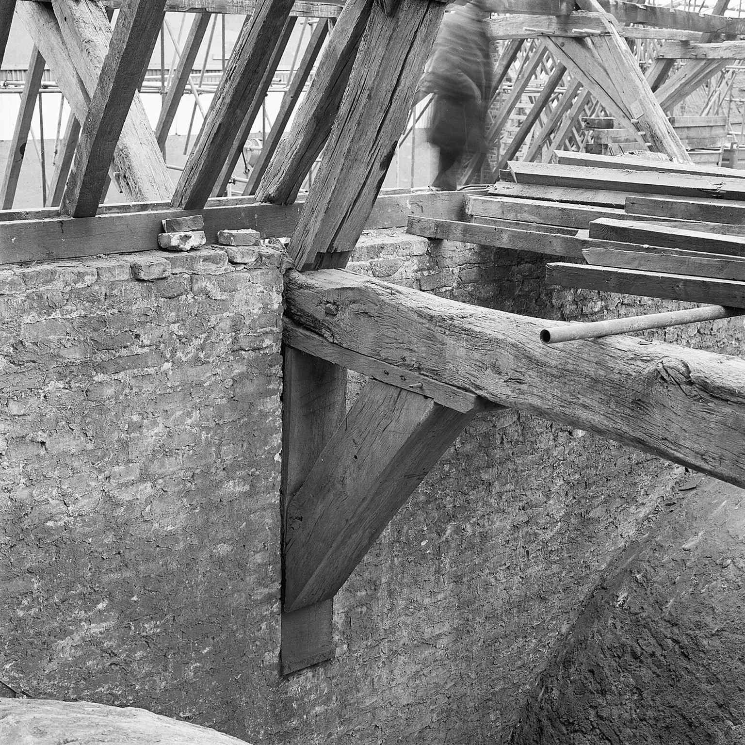 This exposed tie beam illustrates the building's historical construction, with the original medieval roof being destroyed in the 1674 summer storm and replaced by three lower ones.