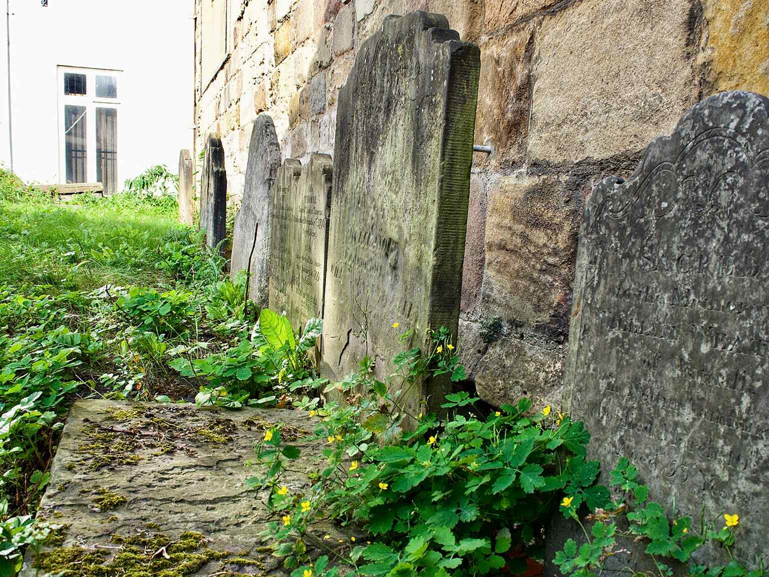 The churchyard gives a wider view of St Michael’s setting on Spurriergate, where the building was shortened and isolated by 19th-century road widening.