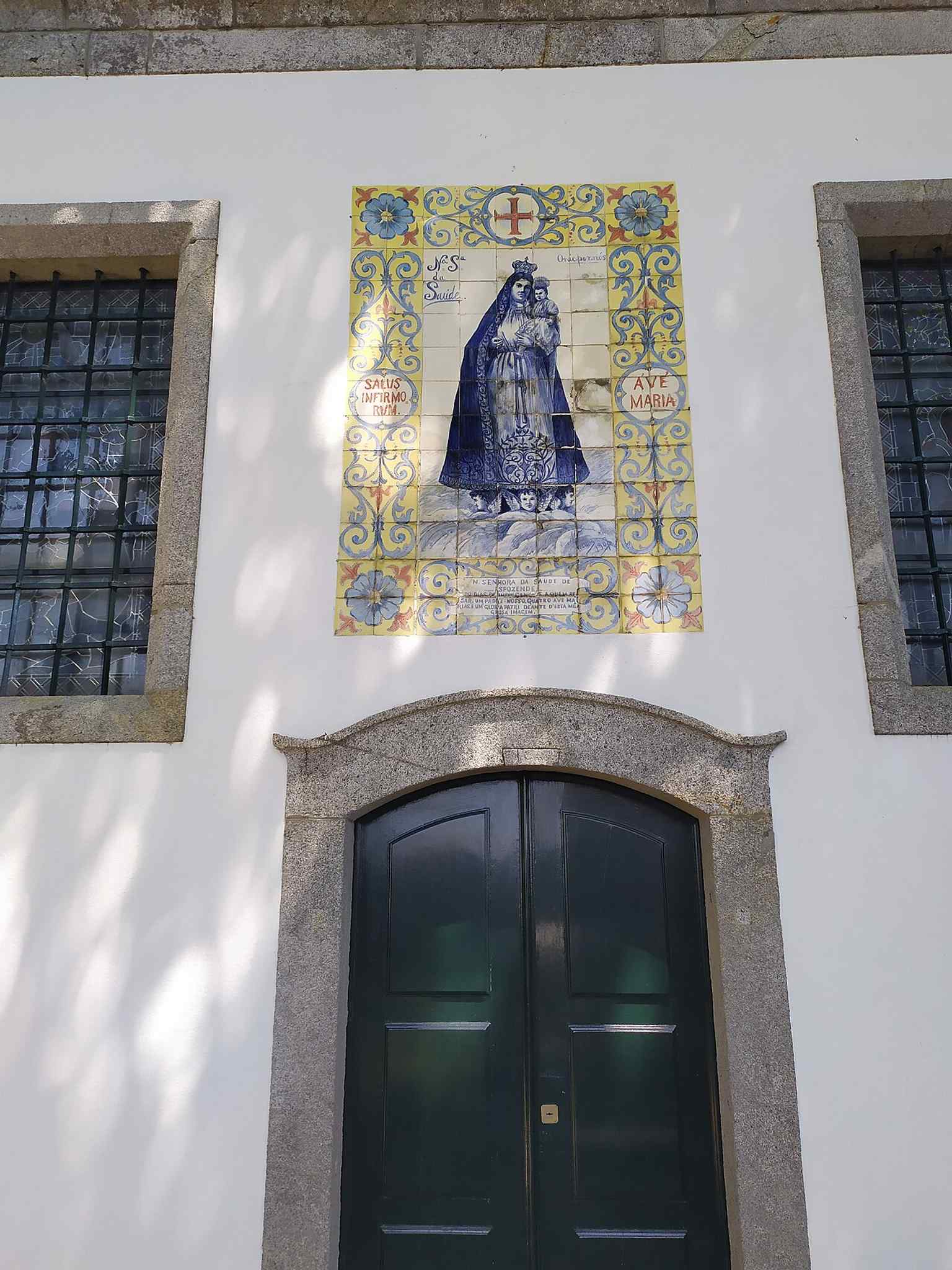 The chapel in its urban setting, with the façade details and the neighboring cross that the source text places beside it.