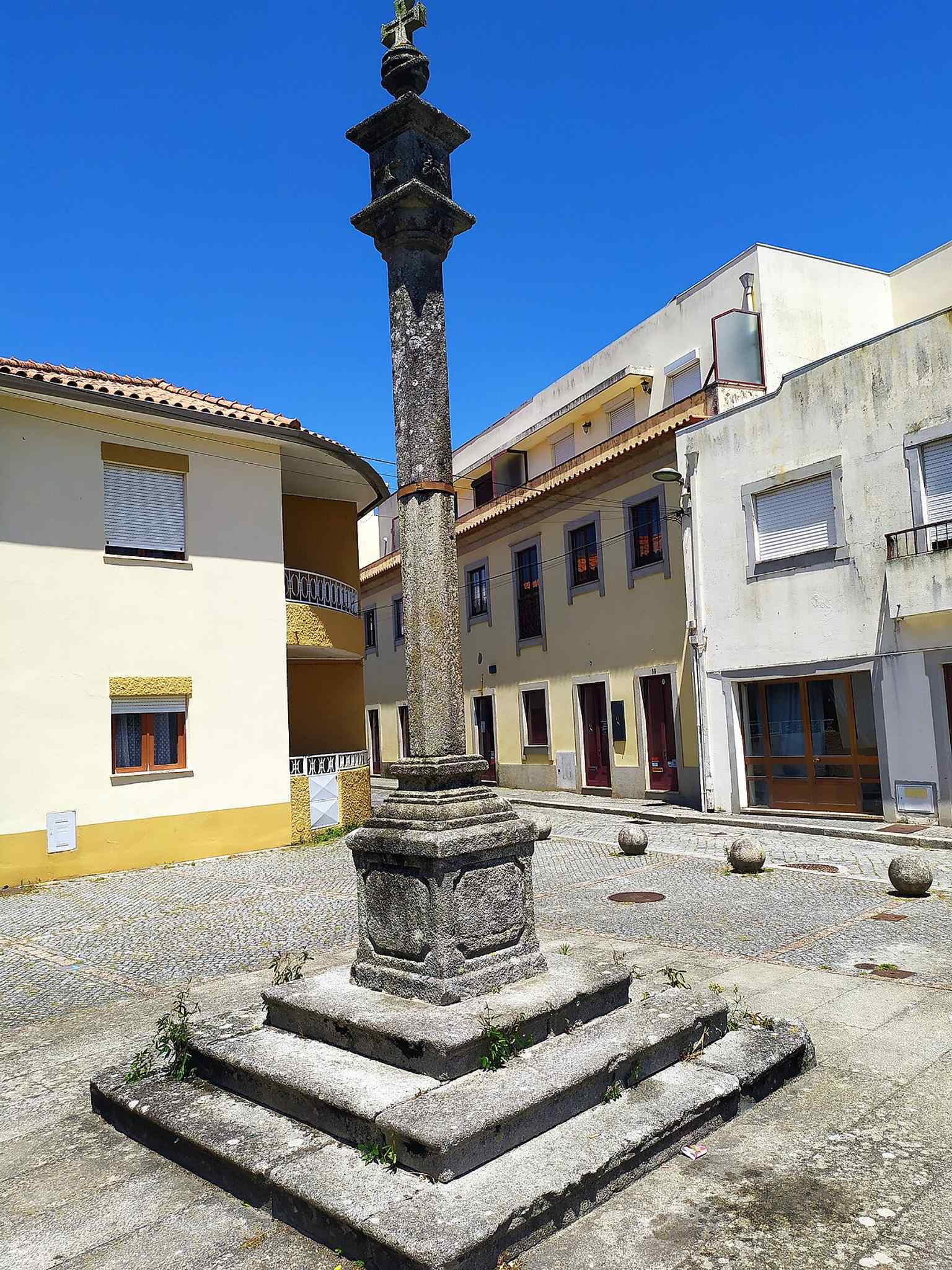 The nearby pillory helps situate the chapel within Esposende’s historic streetscape and gives context for the landmark’s surroundings.
