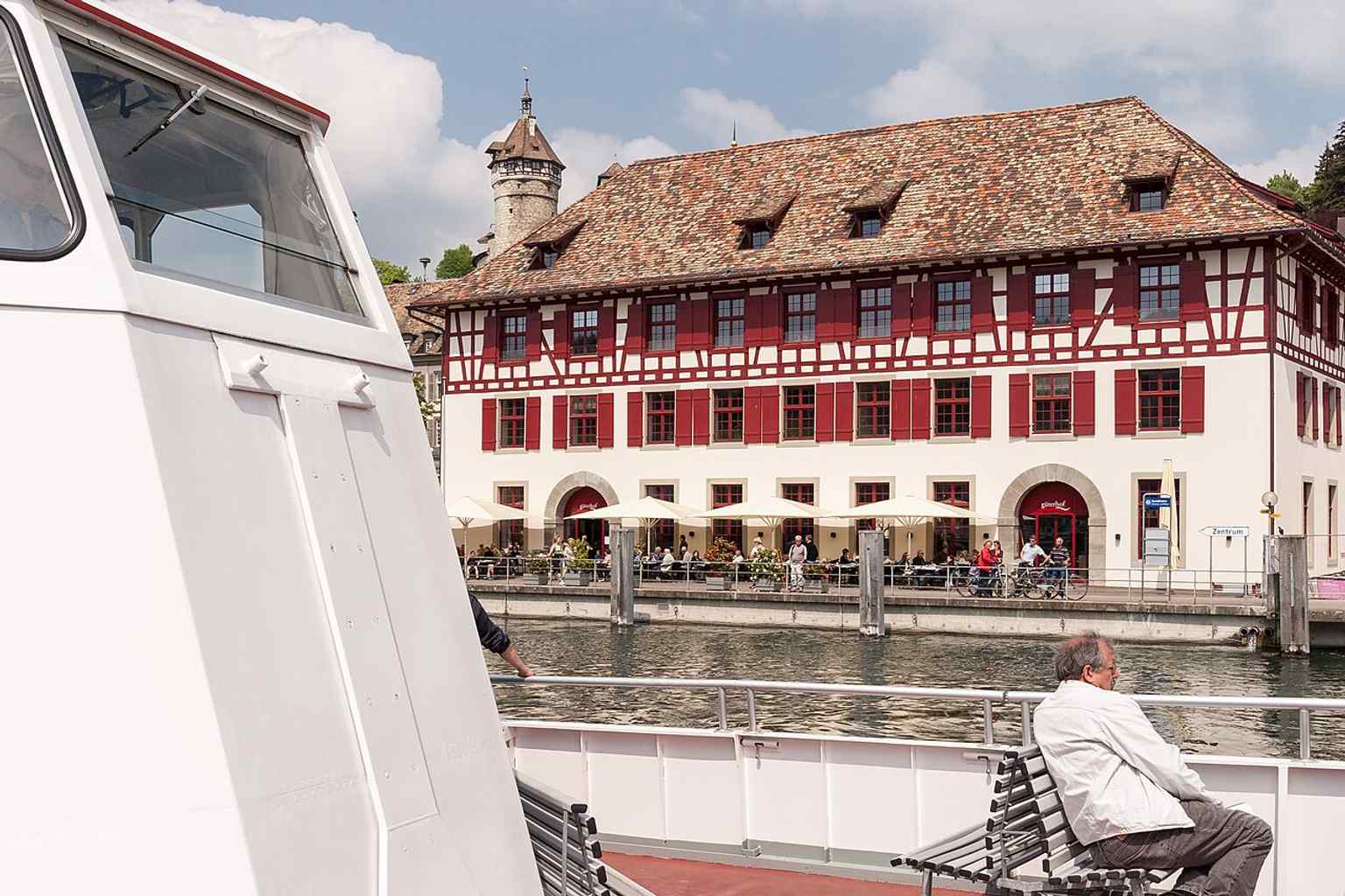 Seen from the Rhine, this classic view shows the Güterhof with Munot in the background — exactly the postcard perspective the building became famous for.