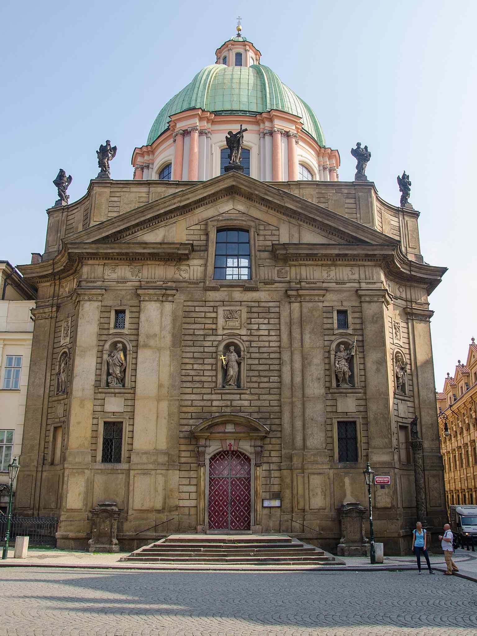 Die barocke Fassade zeigt Engelsstatuen auf dem Attikageschoss sowie Figuren wie die Heilige Agnes von Böhmen, die 1252 die ursprüngliche Kirche und das Krankenhaus gründete.