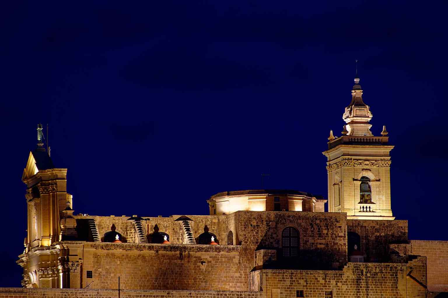 A broad view of the cathedral inside the Cittadella, matching its hilltop setting and the long history built on earlier religious layers.