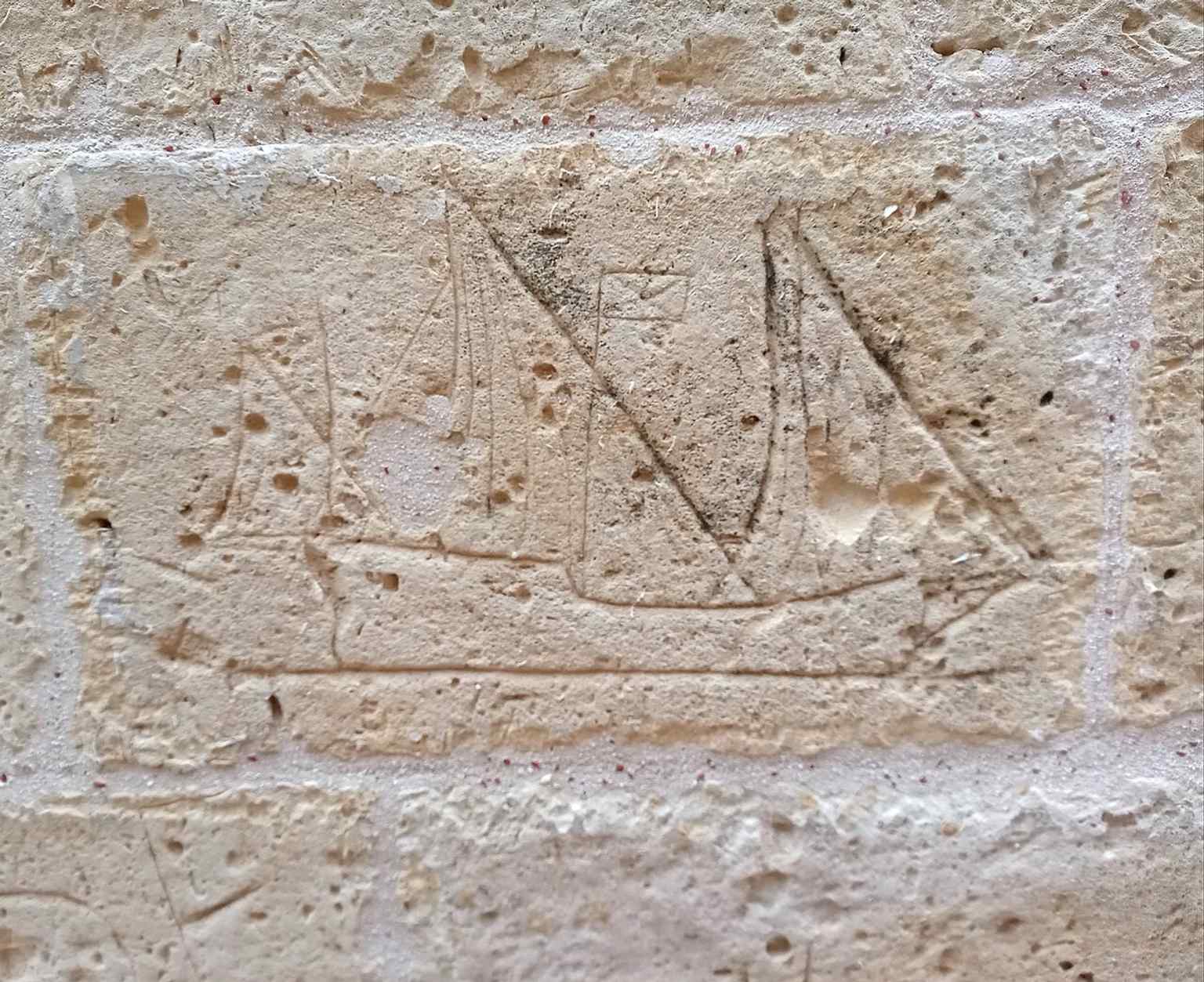 A small graffiti-like sailing boat on the cathedral wall, a human trace on a building layered over centuries of history.