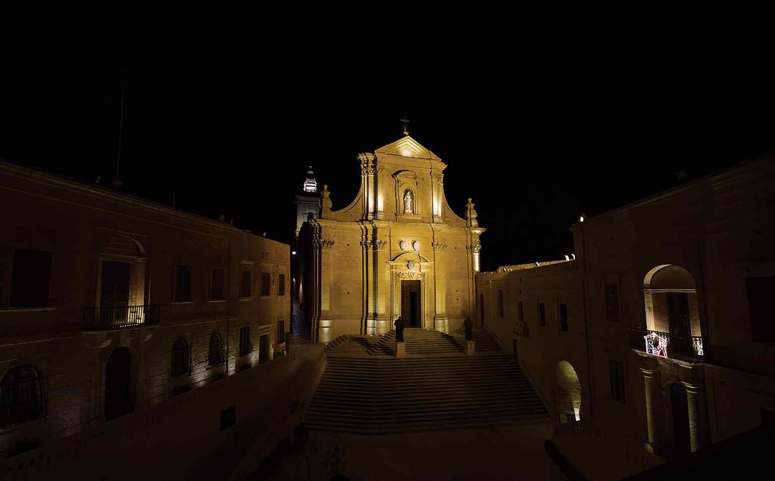 The cathedral at night, giving a dramatic sense of the landmark’s presence above Victoria and within the fortified Cittadella.