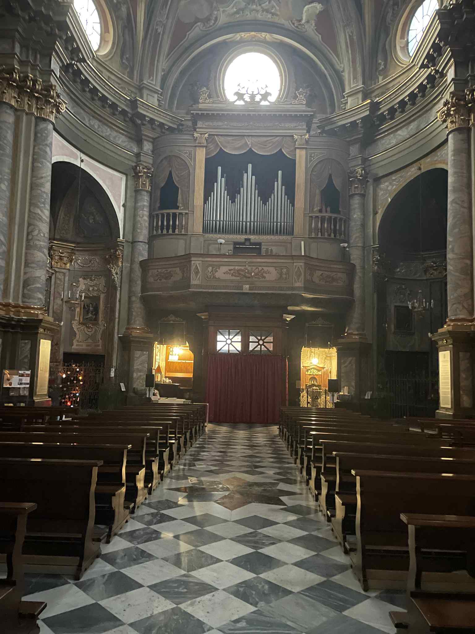 Look up at the prestigious dome, where the painter masterfully depicted Saint Ambrose radiant with a celestial vision amidst dancing angels.