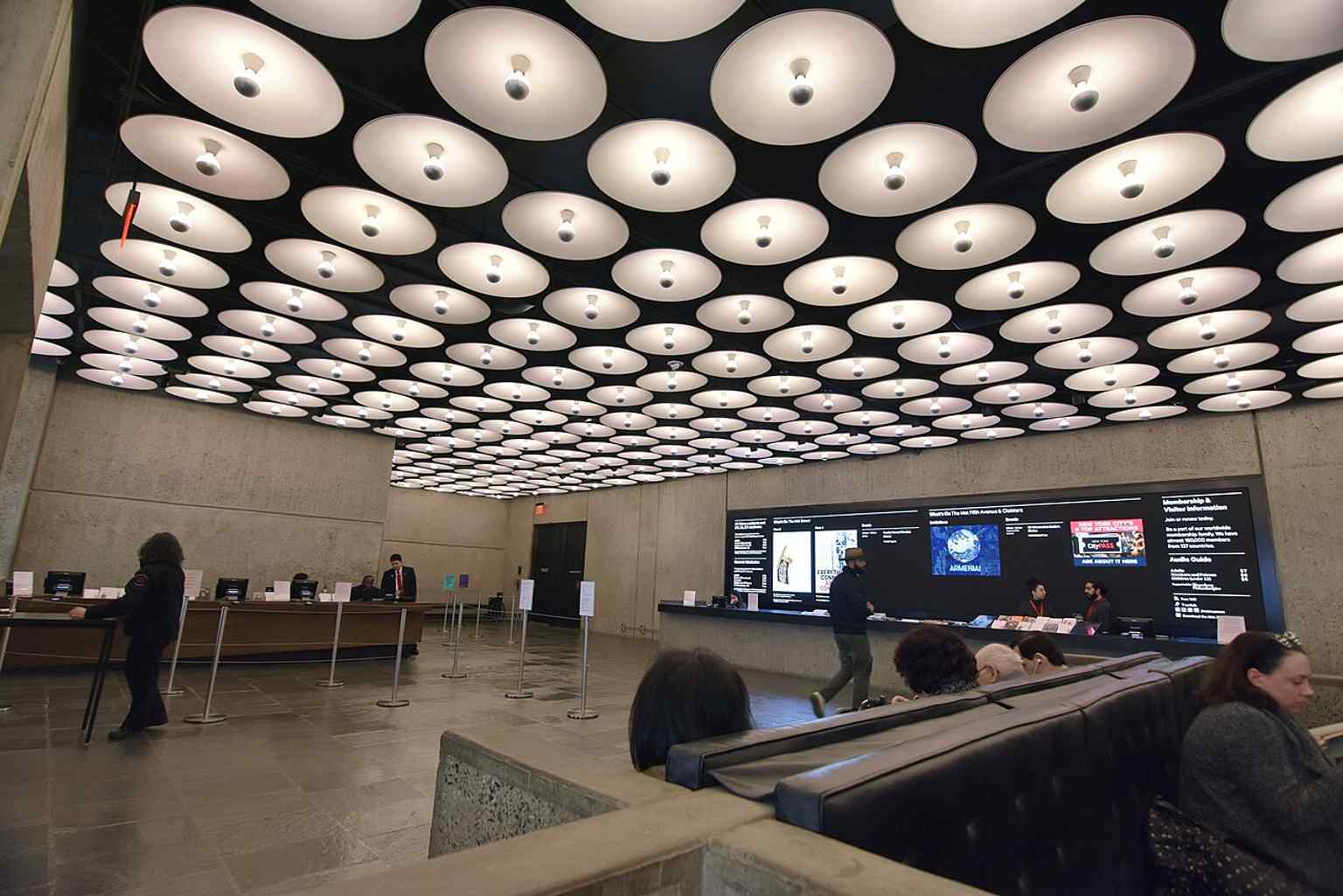 The lobby of the Met Breuer, showcasing the meticulous restoration that preserved the authentic patina of materials like bronze fixtures and darkened the bluestone floors to Marcel Breuer's original somber vision.