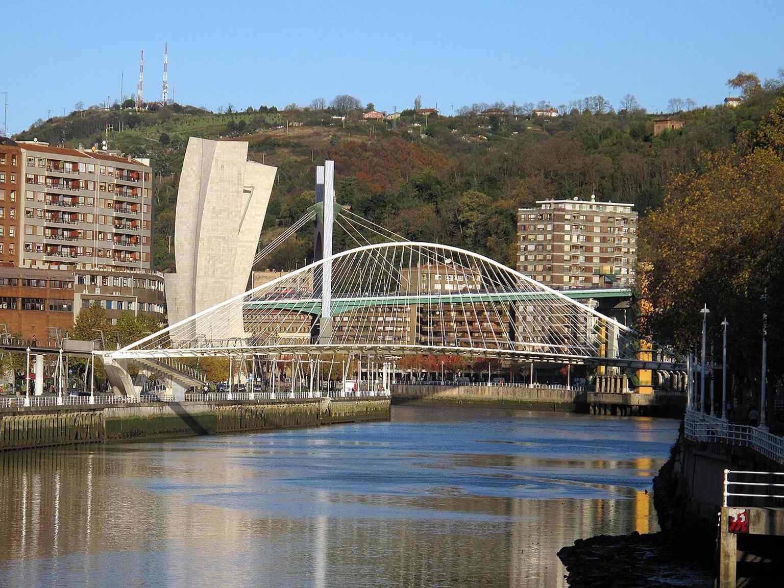A classic side view of the White Bridge, showing Santiago Calatrava’s elegant 1990s design over the Nervión River.