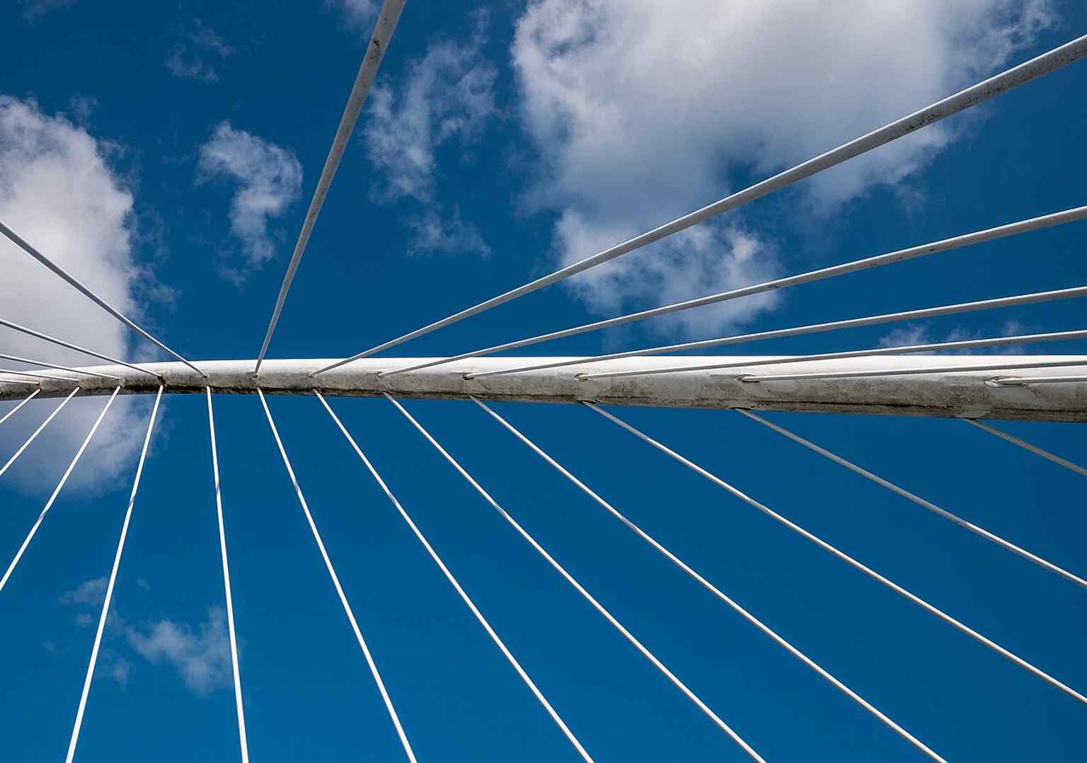 An upward-looking view that emphasizes the inclined arch and cable-supported deck — the bridge’s most distinctive structural feature.