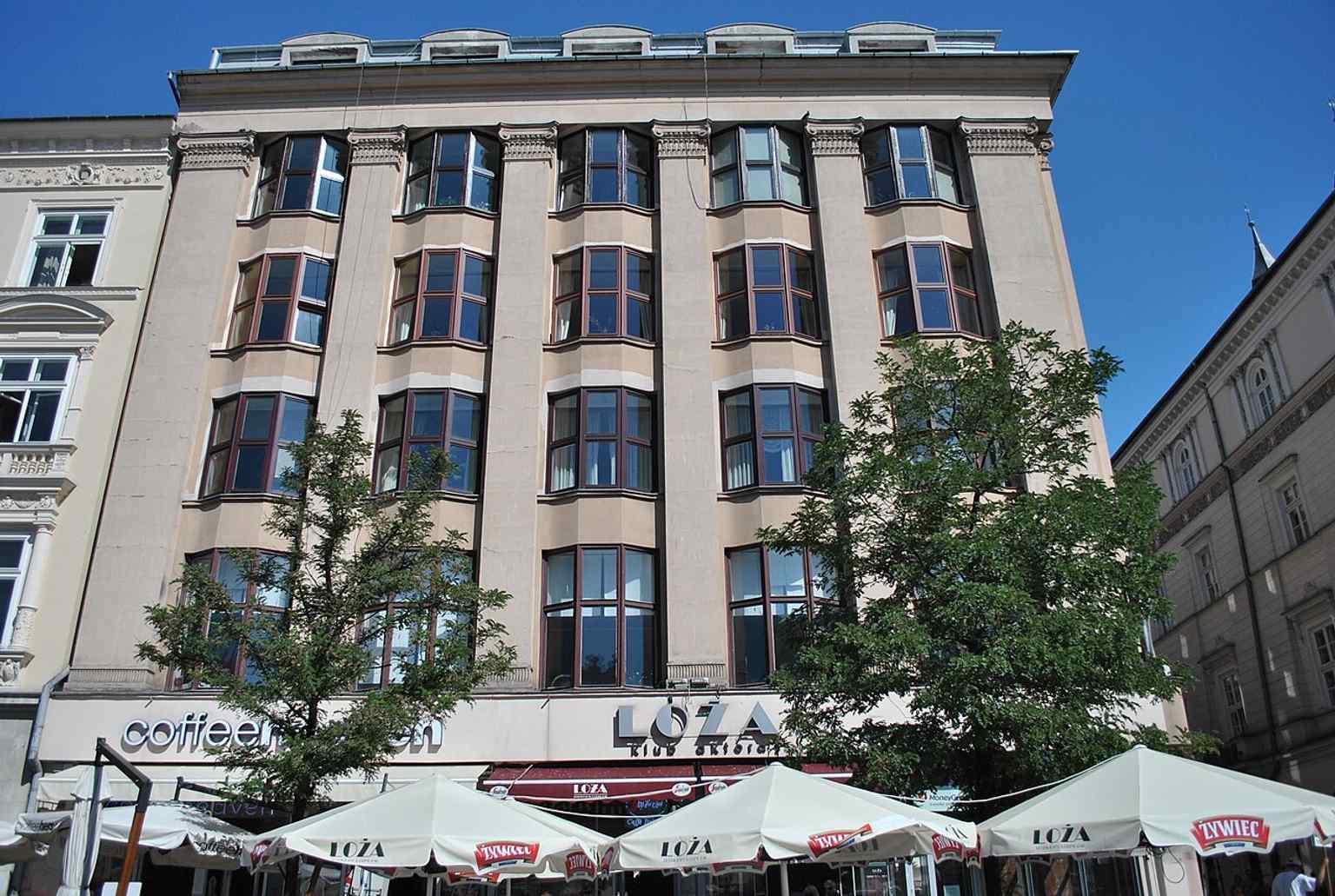 Eine aktuelle Ansicht auf Straßenniveau, die zeigt, wie Feniks auch heute noch die Ecke der Krakauer Altstadt verankert.