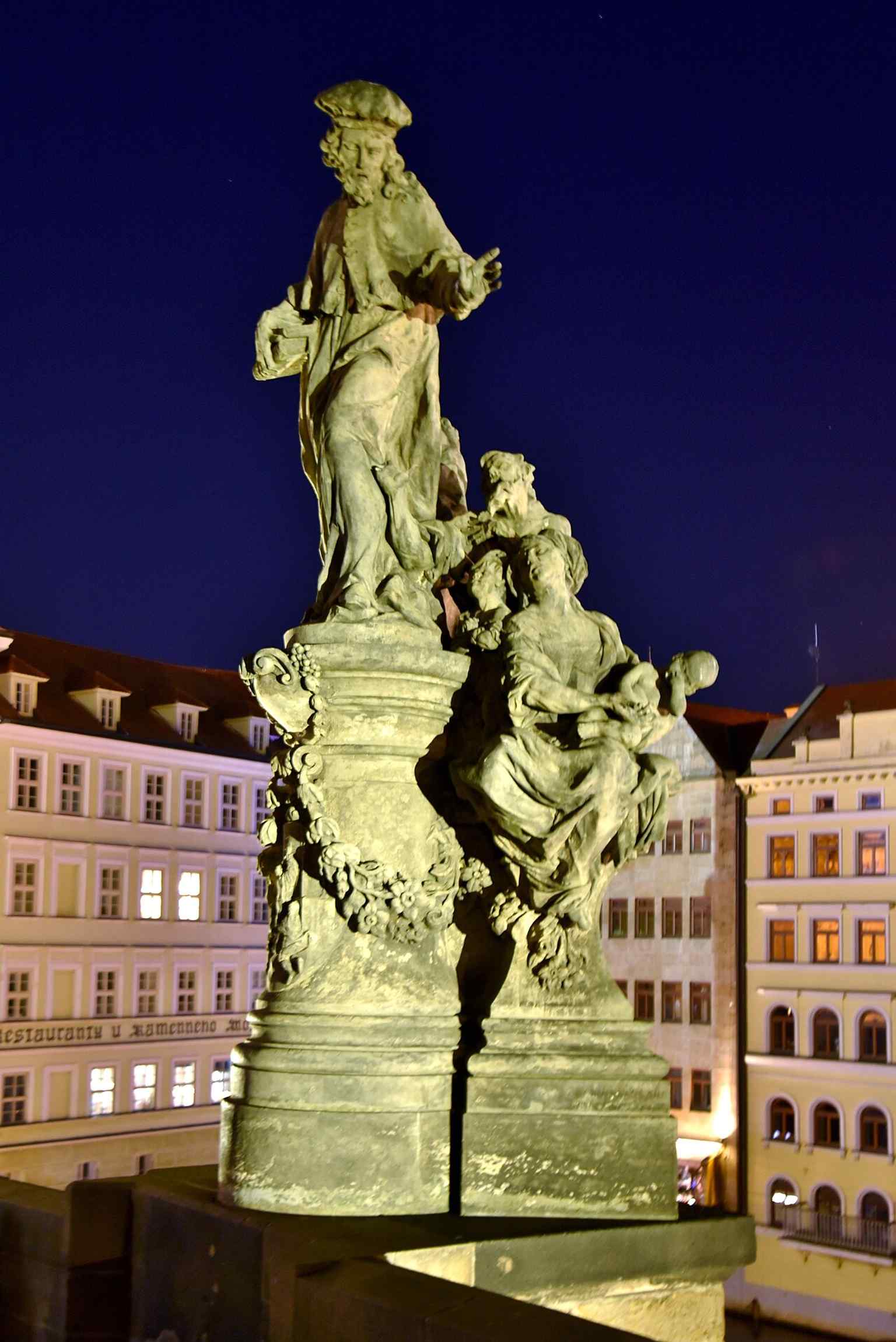 The Statue of Ivo of Kermartin on the Charles Bridge, a grand display commissioned in 1711 by Charles University's Faculty of Law to honor their patron saint.