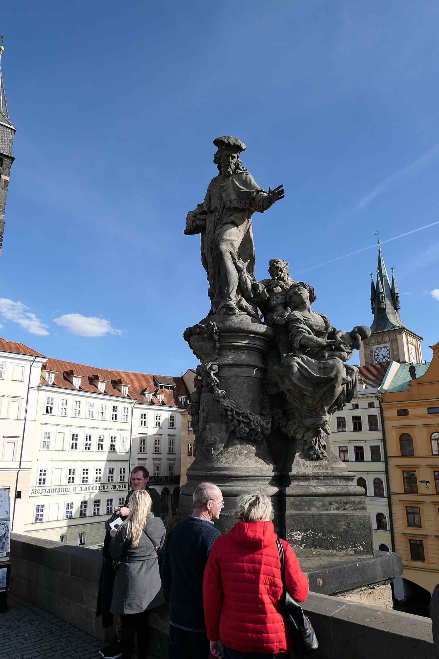 The Statue of Saint Ivo stands as one of the many Baroque sculptures adorning Charles Bridge, a traditional spot where law students once prayed for luck before exams.