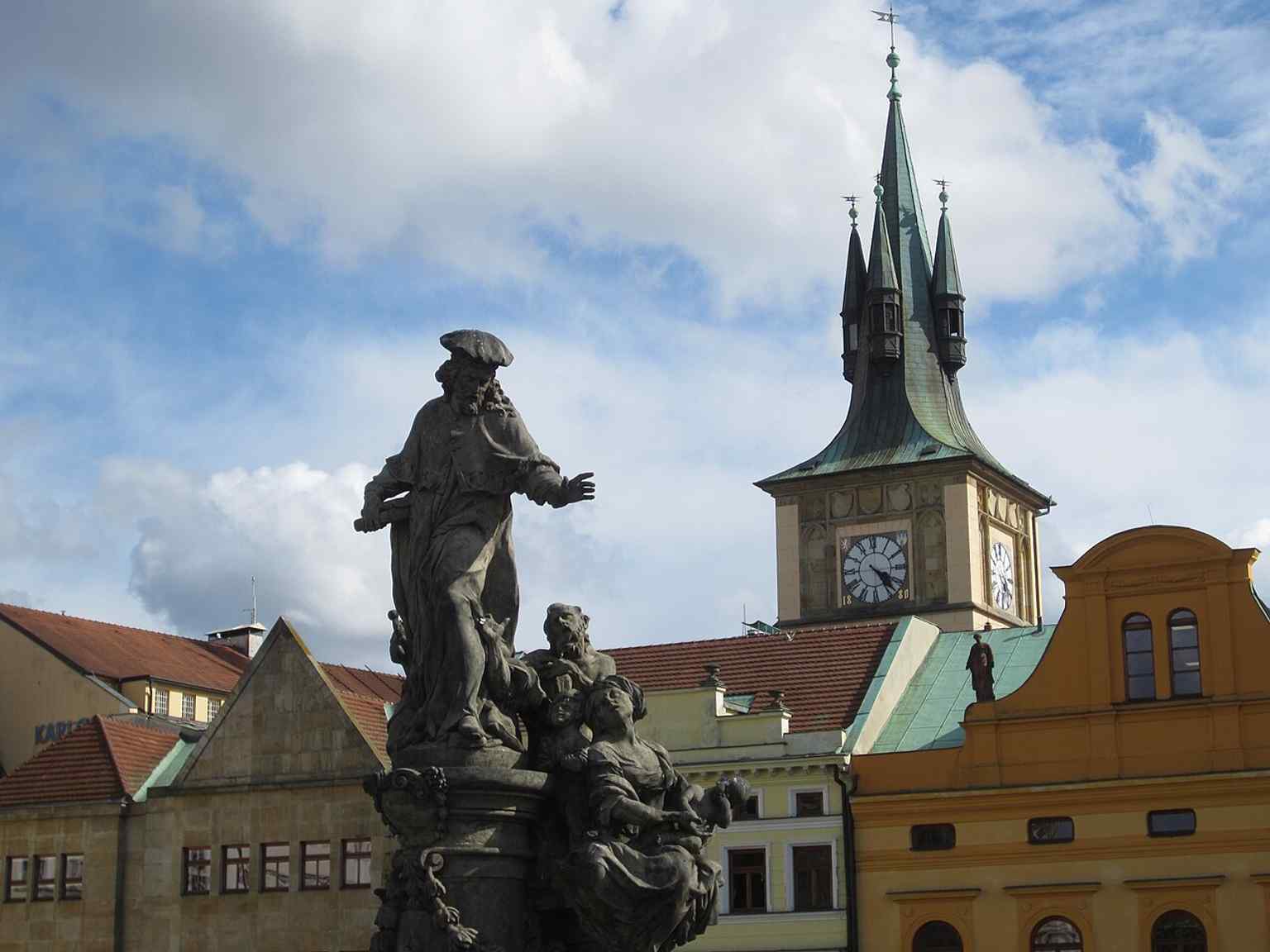Crowds gather around the statues on Charles Bridge, reminiscent of the centuries-old tradition where Charles University law students would offer prayers to Saint Ivo before their examinations.