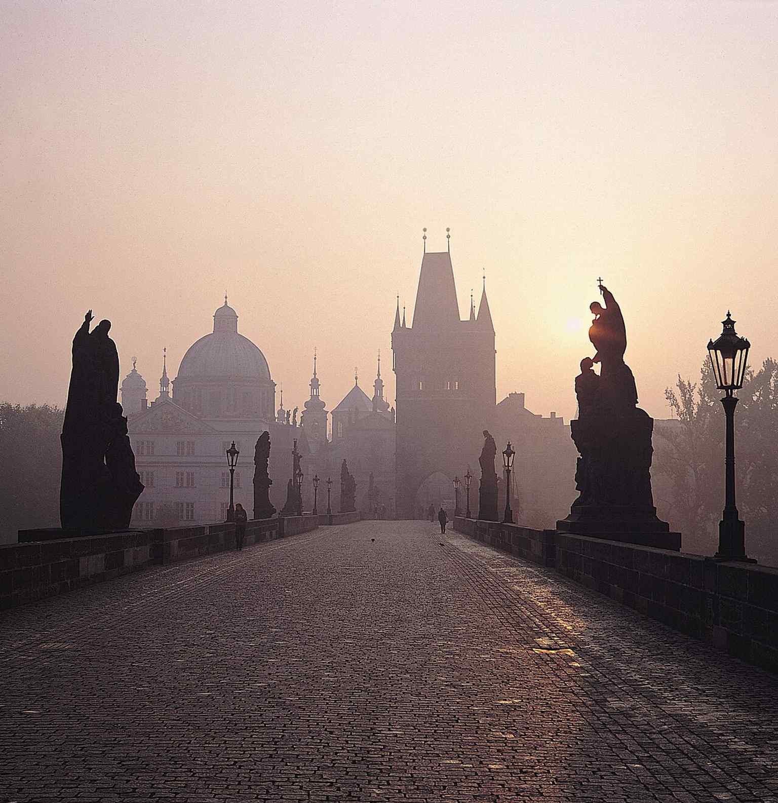 A morning view of the Charles Bridge, where the statue stands on the south side, serving as a lasting reminder of the bridge's vulnerability to the elements.