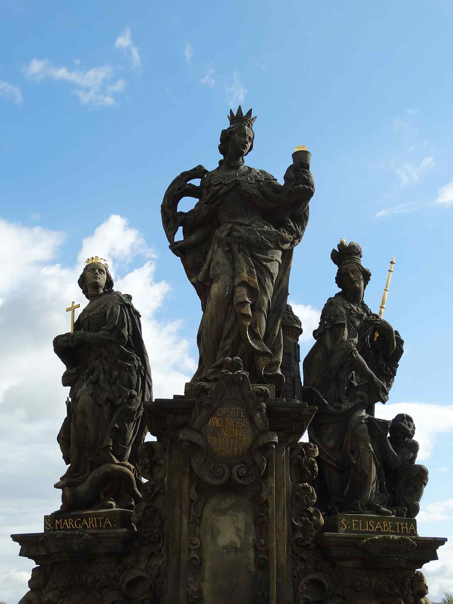 The monumental base of the sculptural group, crafted from fine-grained sandstone, which has remained largely intact for over three centuries on the Charles Bridge.