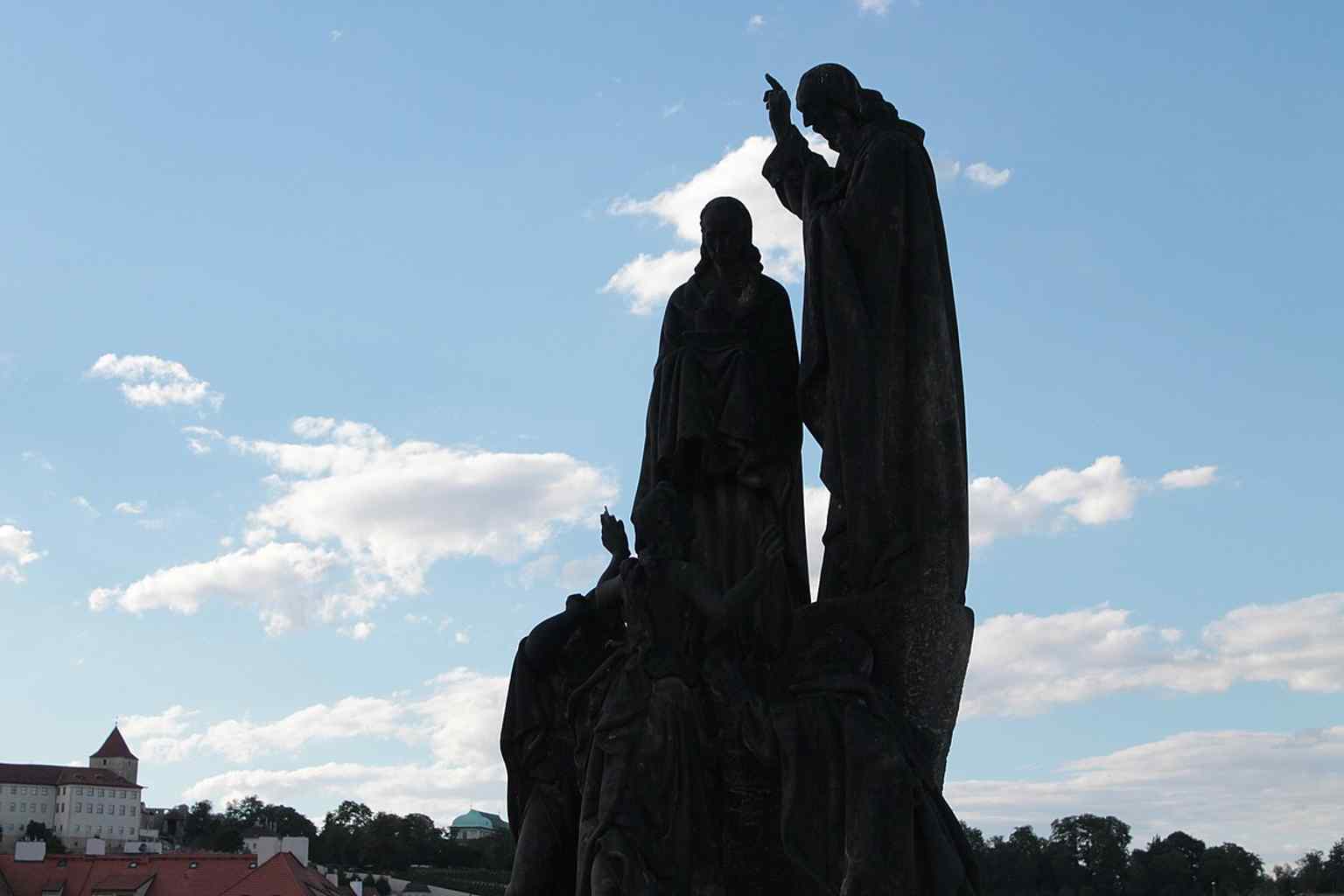 The Saints Cyril and Methodius statuary bathed in the warm light of sunset, representing a symbolic bridge between medieval history and modern Czech identity.