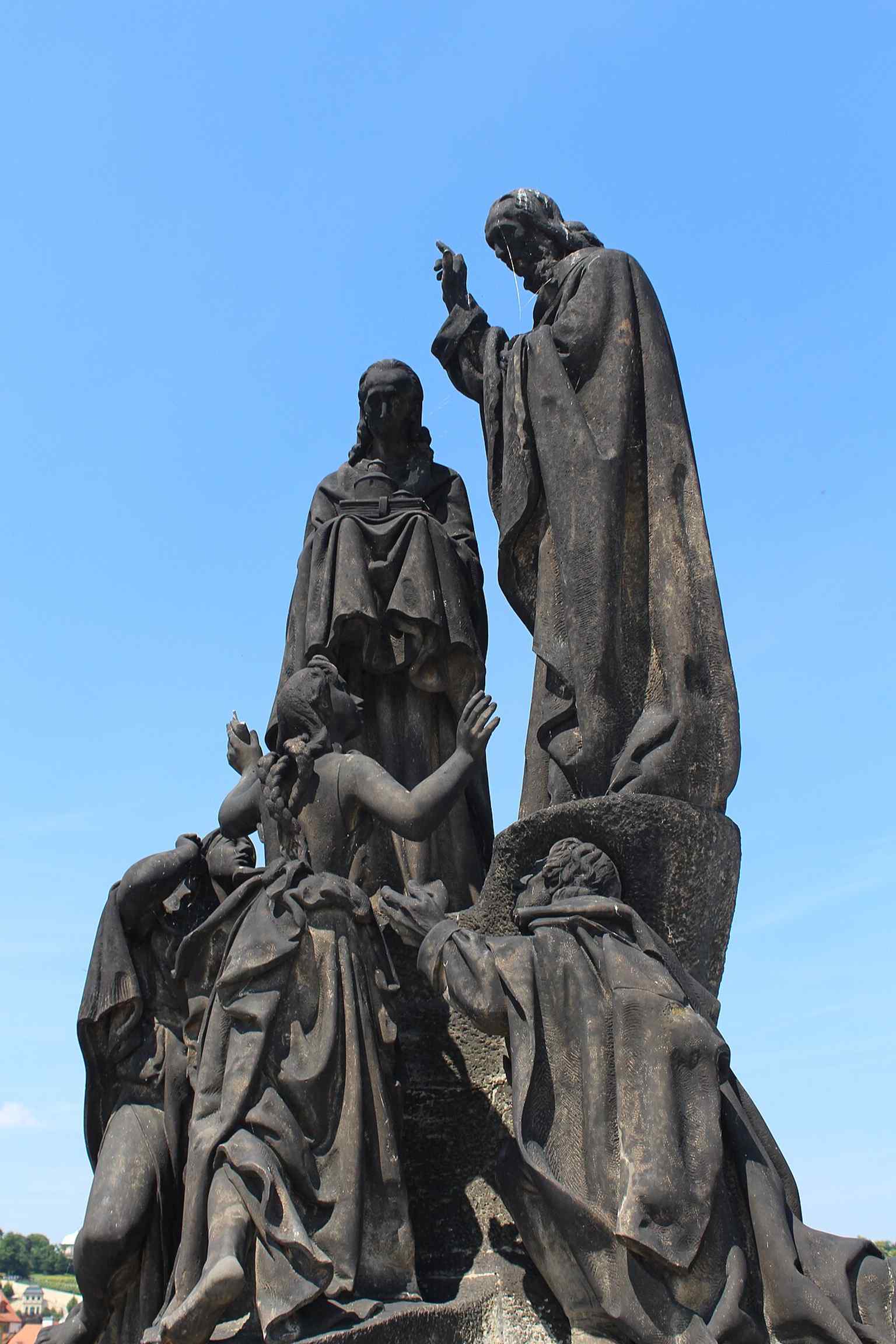 A side perspective of the Saints Cyril and Methodius sculpture, showcasing its integration among the many revered statues lining the historic Charles Bridge.