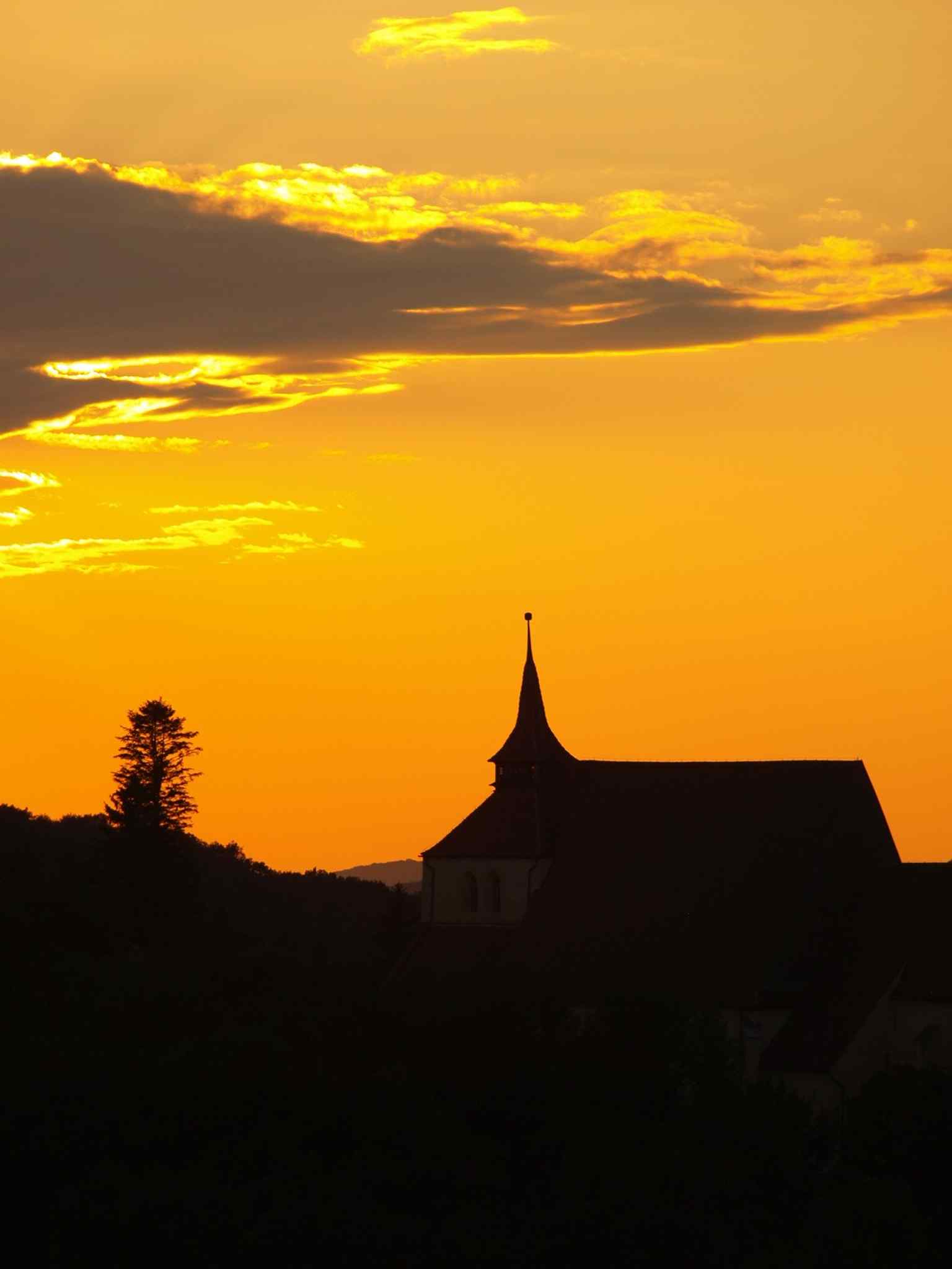 Experience the Church on the Hill at sunset, a monumental landmark visible from great distances that defines the Sighișoara skyline.
