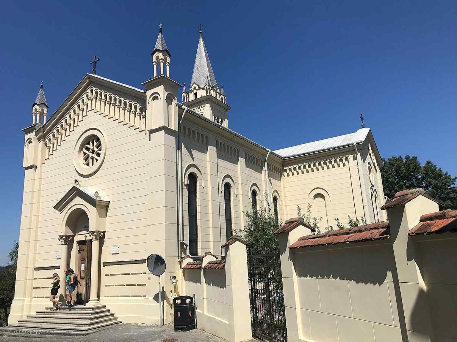 This exterior view highlights the church's vibrant yellow facade and tall belfry, a striking eclectic design that set it apart from the city's Saxon churches when it was built.