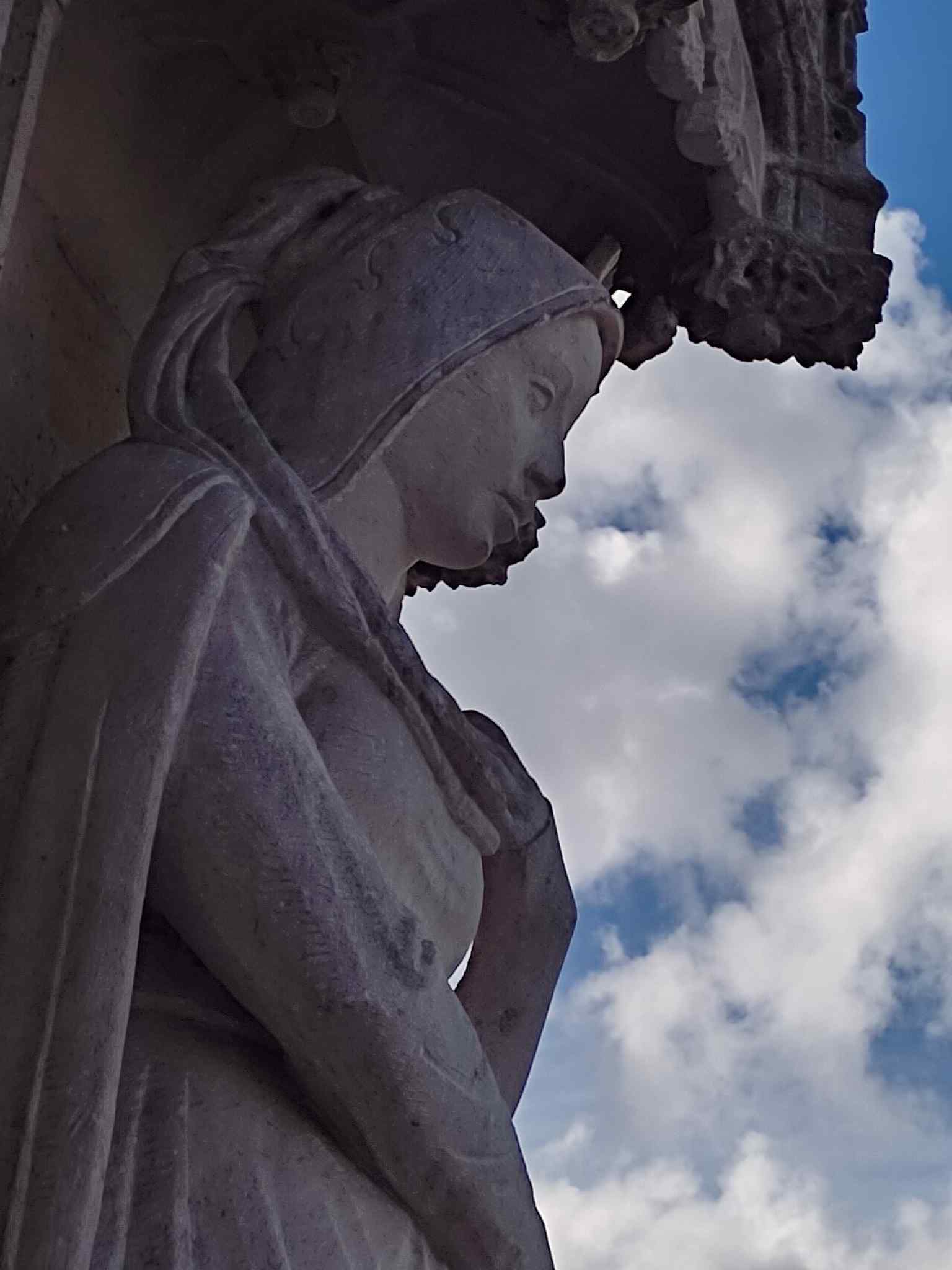 A close-up of a sculpted figure on the façade, part of the 236 statues that now animate the building’s once-empty niches.