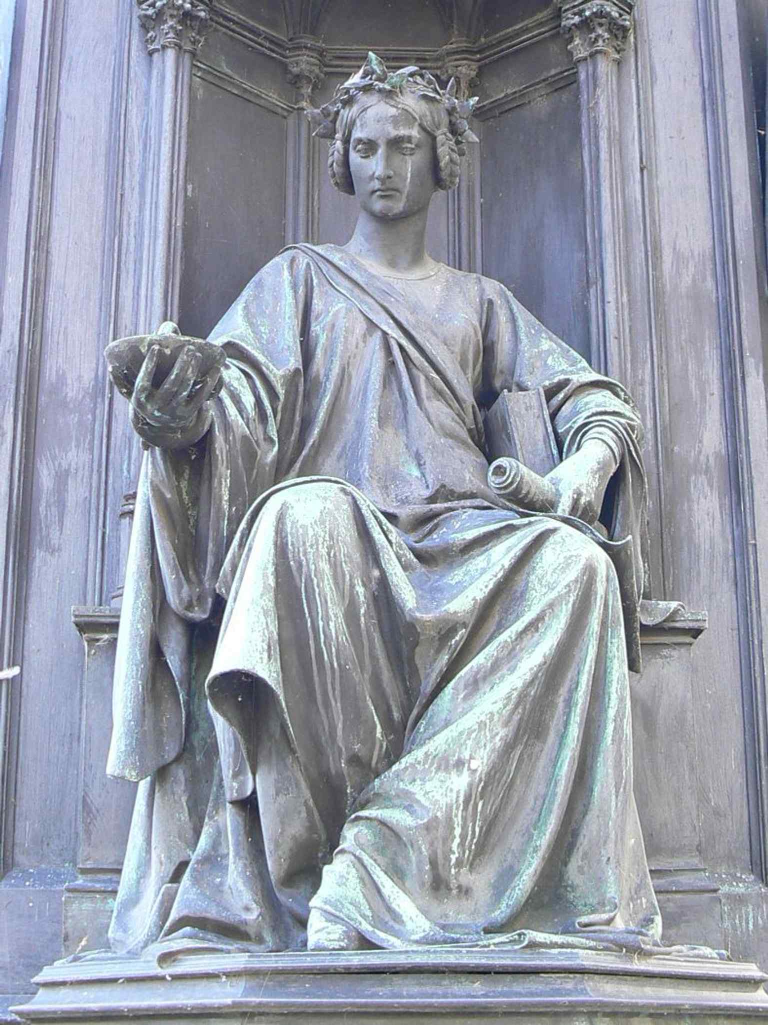 The Faculty of Medicine is honored by this figure on the pedestal, part of the statue's tribute to Charles IV's role in establishing the university.