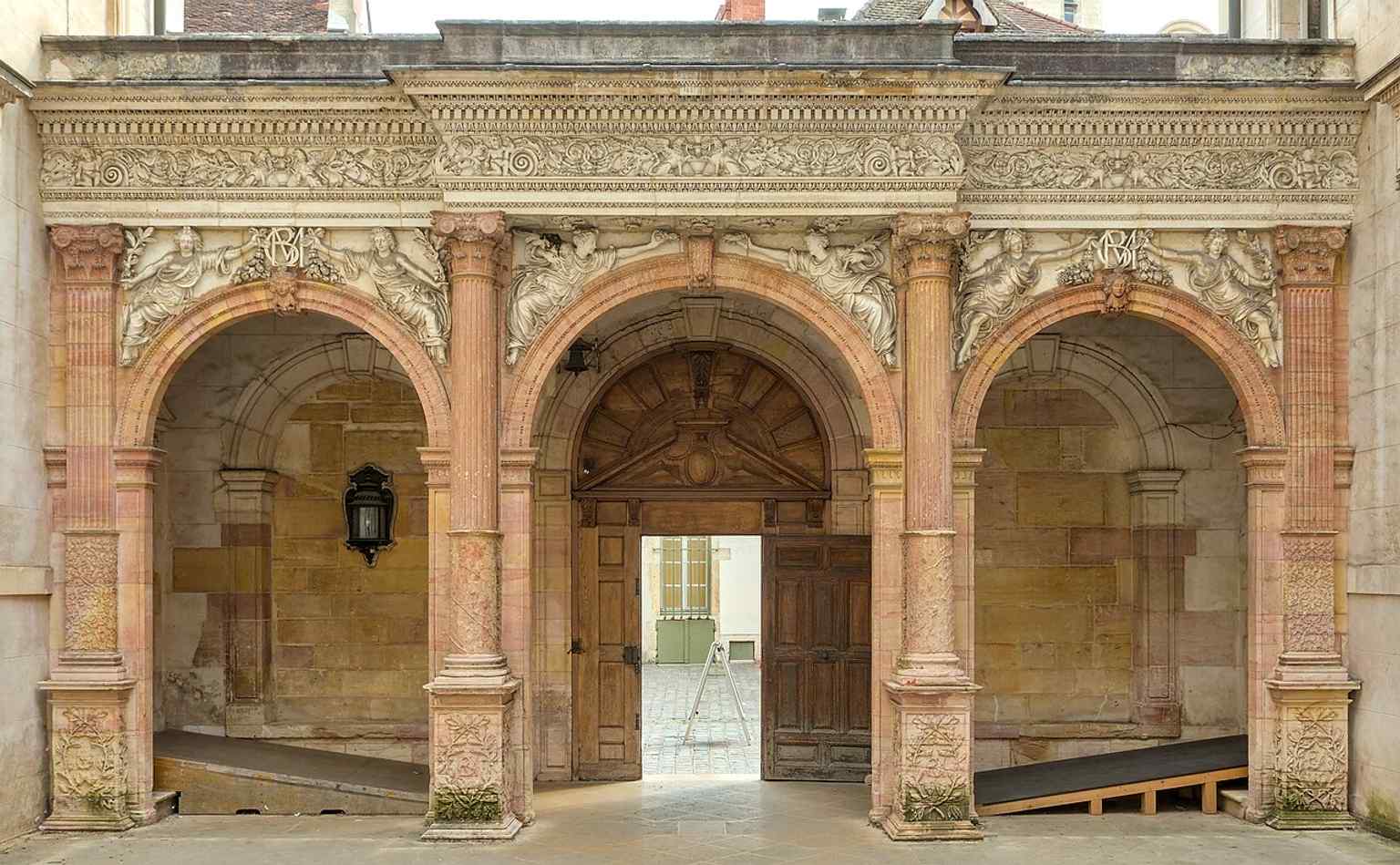 Observe the elegant Italian-style portico in the courtyard, adorned with intricate decorations, including intertwining ivy on the columns and the monogram E.B.M.G. of its builder Étienne Bouhier.