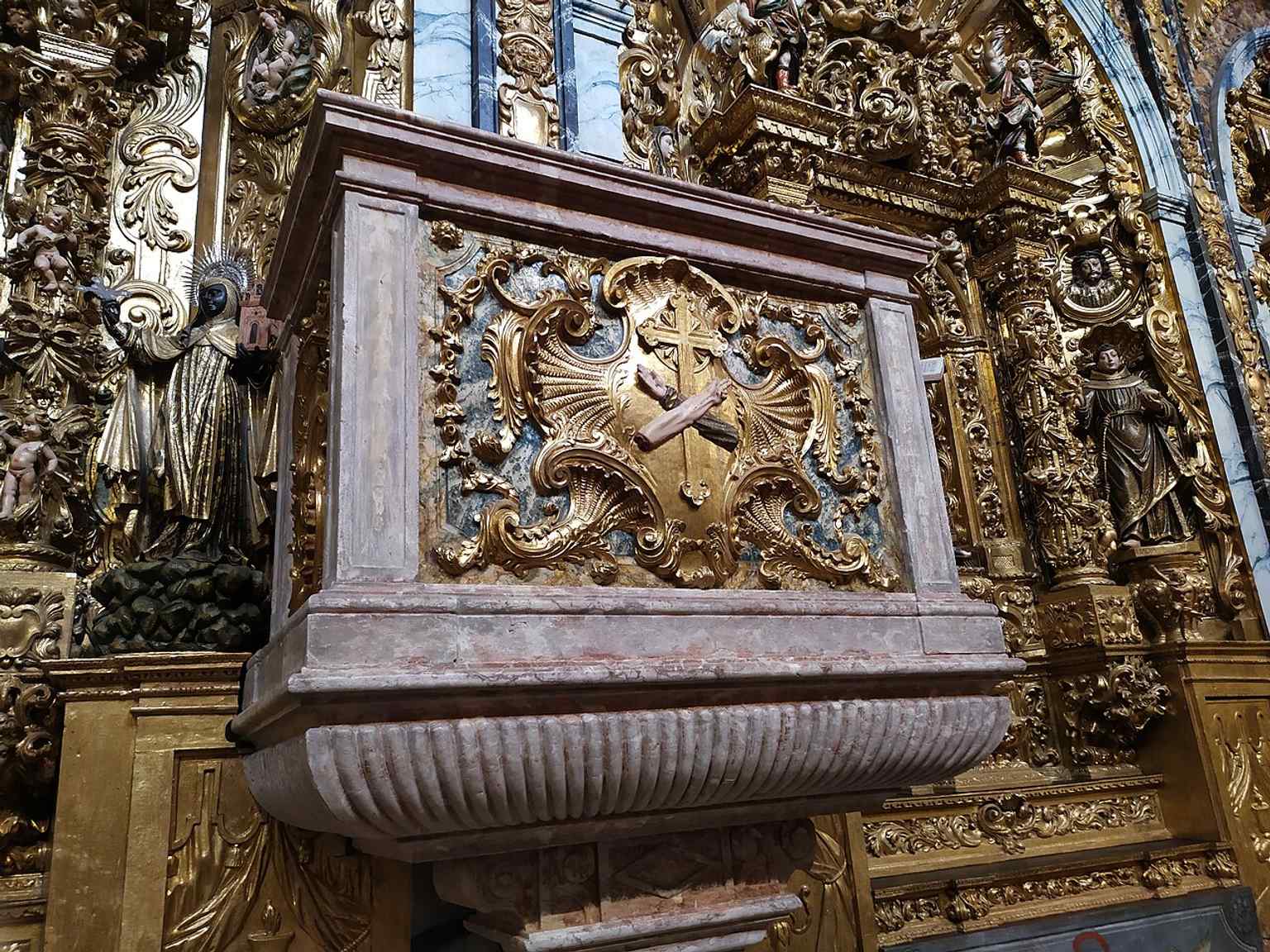 An interior glimpse of Santa Clara, giving context for the church’s richly ornamented Baroque environment beyond the main altar.