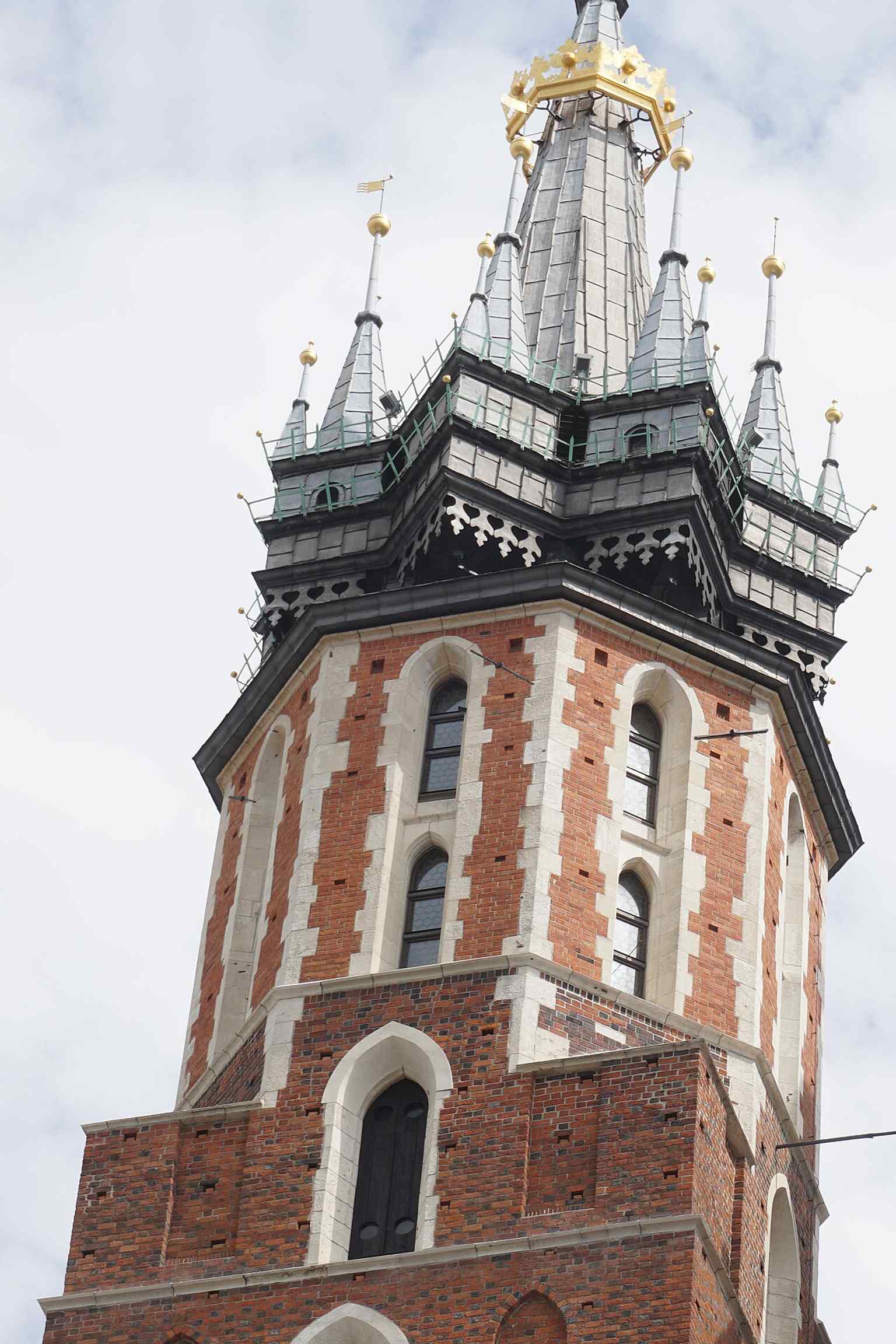 Die Kirche erscheint hier als zentrales Wahrzeichen Krakaus in der historischen Stadtlandschaft und entspricht ihrem Status als Stadtsymbol.