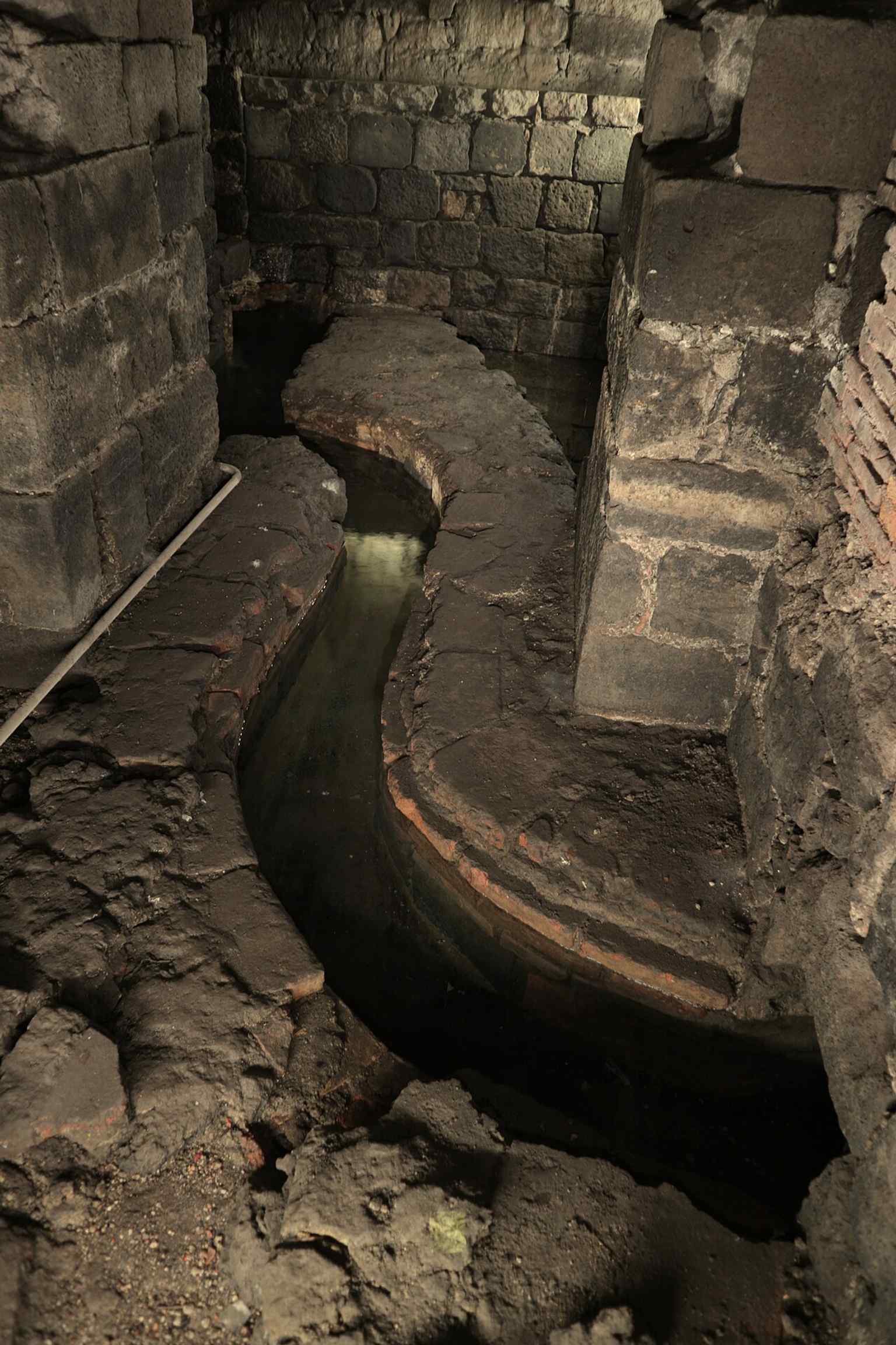 The drainage and water-management remains of the baths — a fitting detail for a site shaped by channels, filtration, and the unpredictable underground river.
