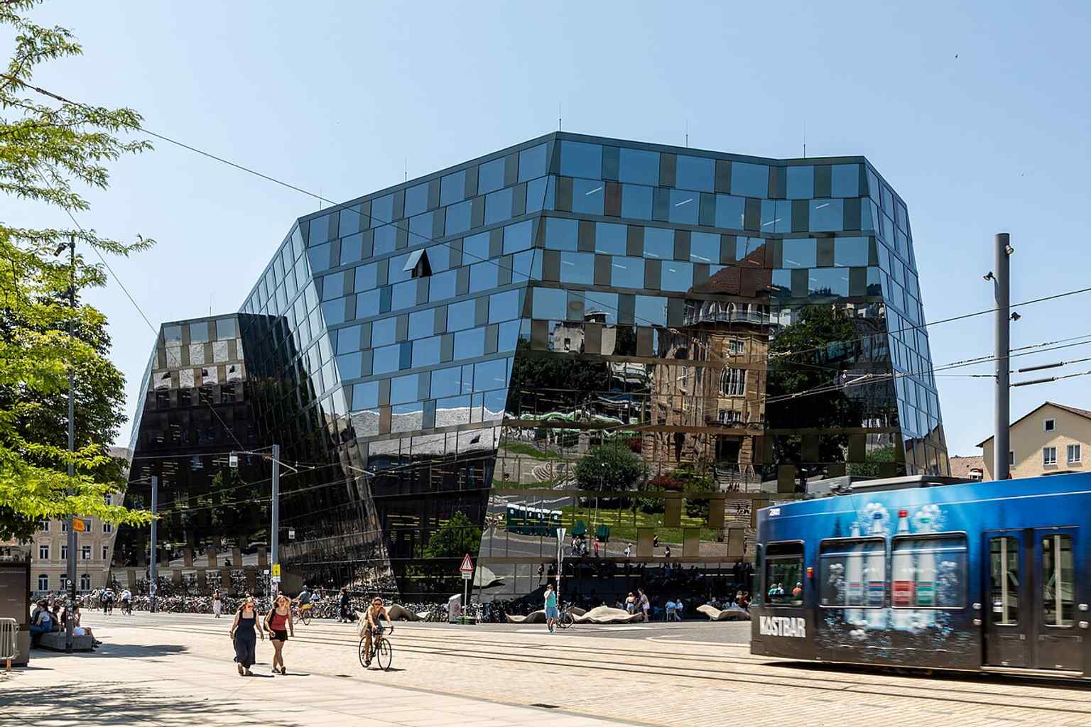 A street-level view with a tram nearby, showing how the university library is embedded in Freiburg’s transport network.