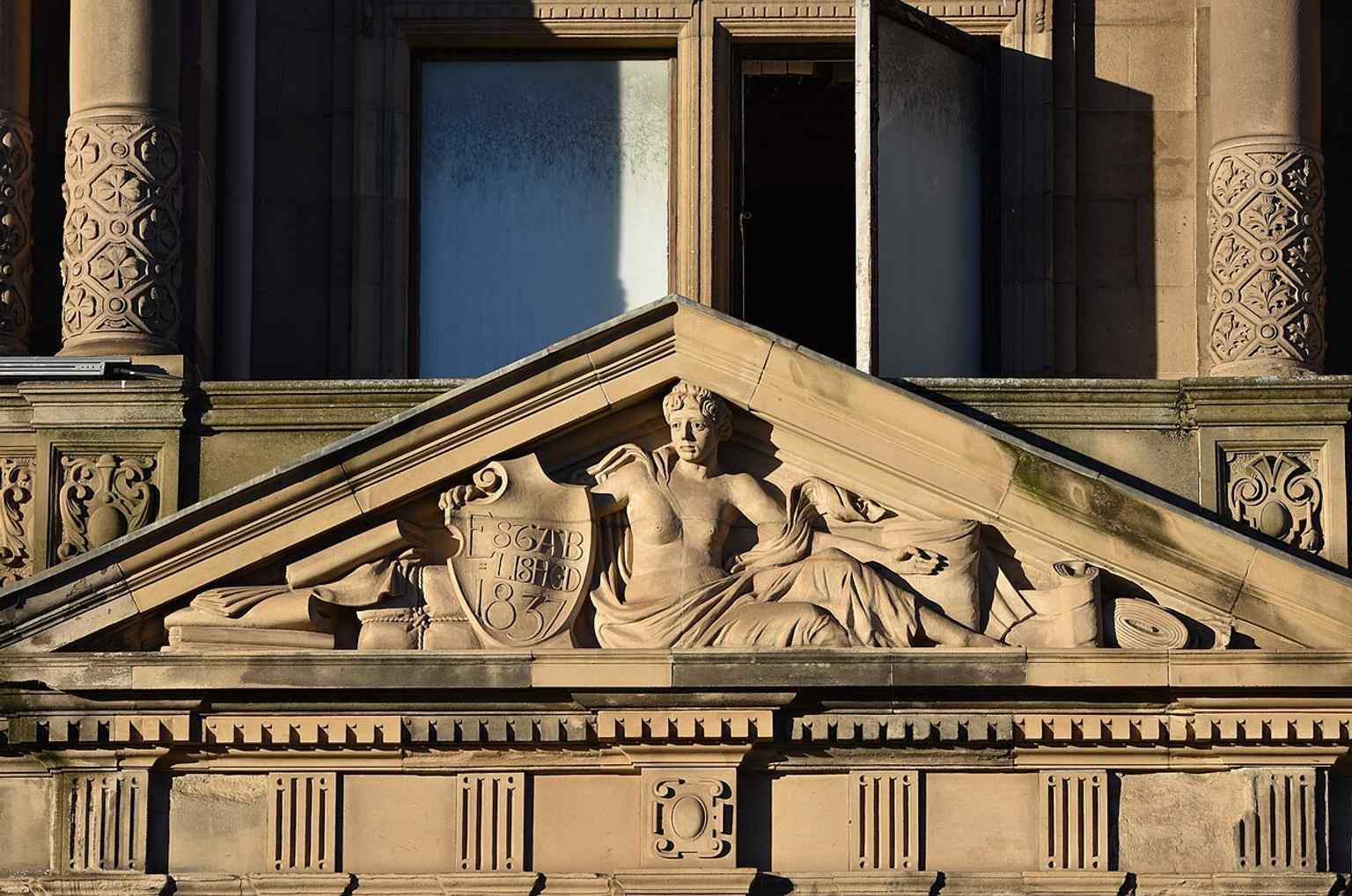 A classical female figure with the founding date, echoing Jenners’ ornate Victorian façade and symbolic decoration.