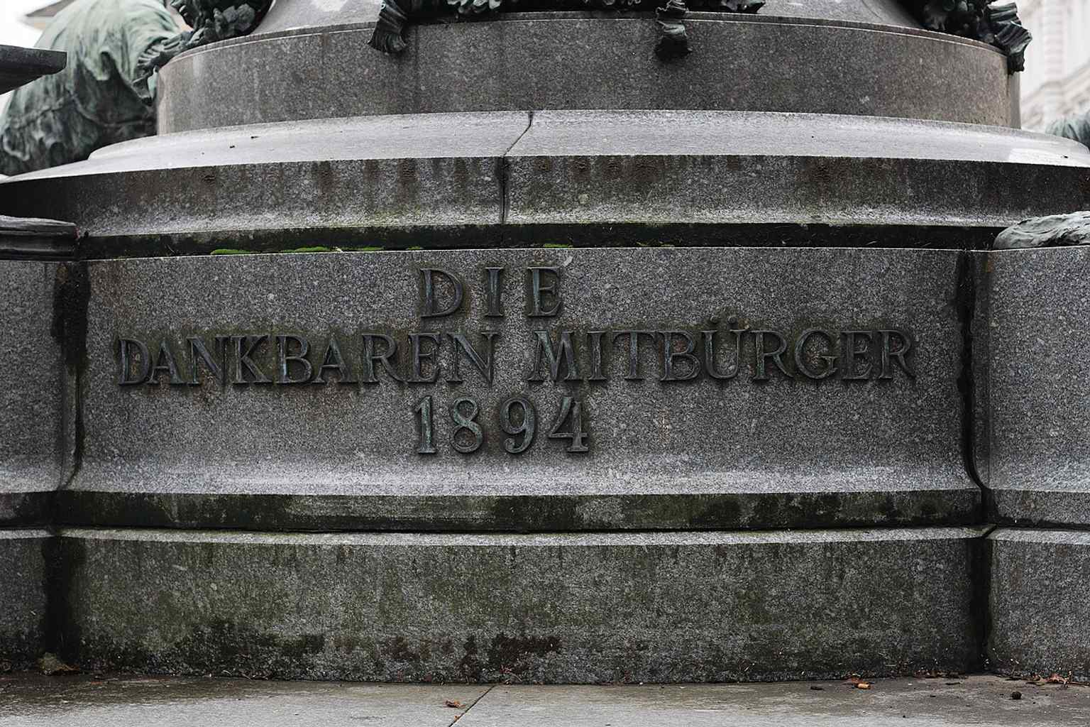 Close detail of the back inscription, linking the monument to the grateful citizens who commissioned it in 1894.