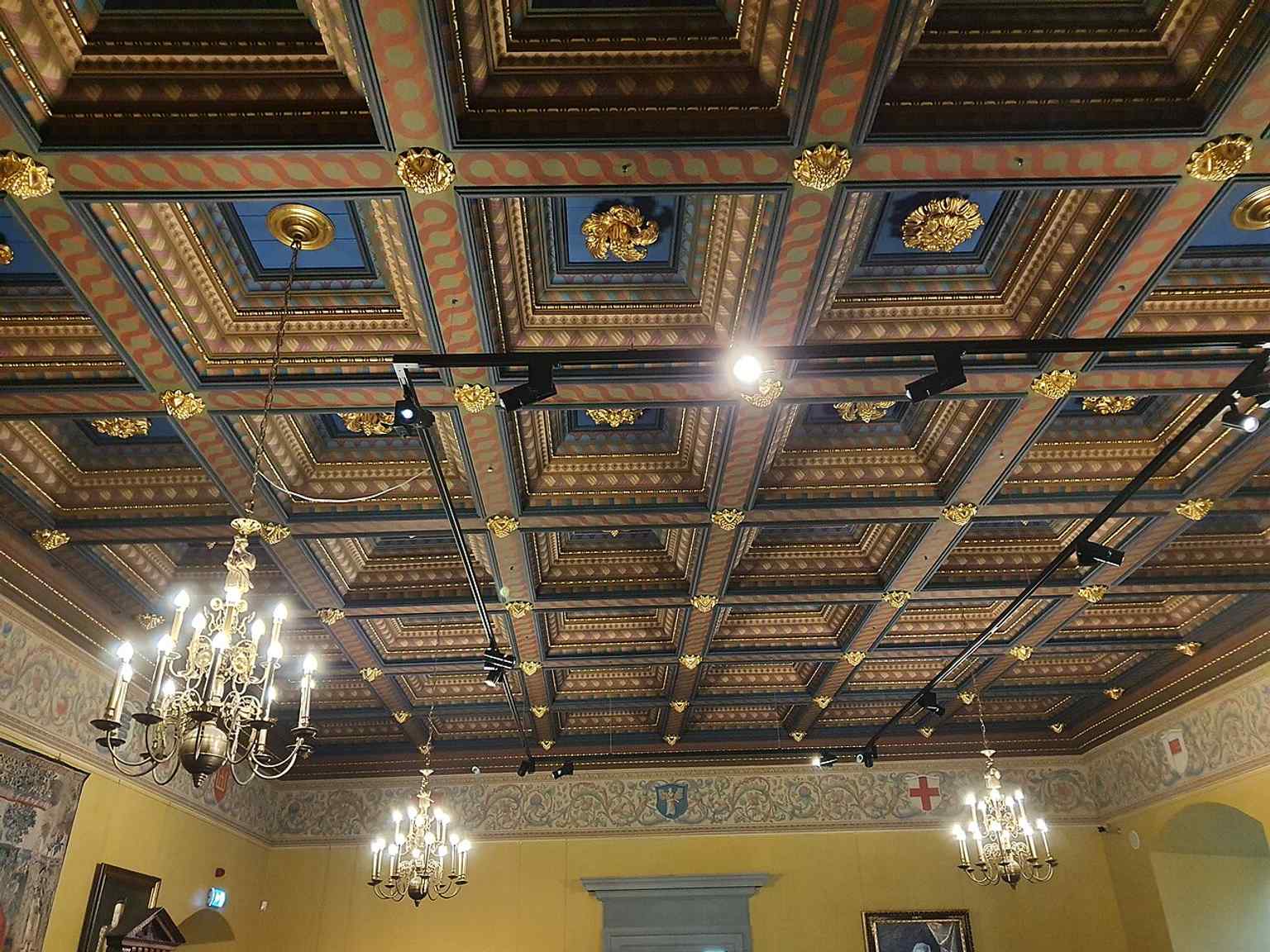 The coffered ceiling in the Lower Representative Hall shows the Renaissance-inspired finish used in the rebuilt palace interiors.