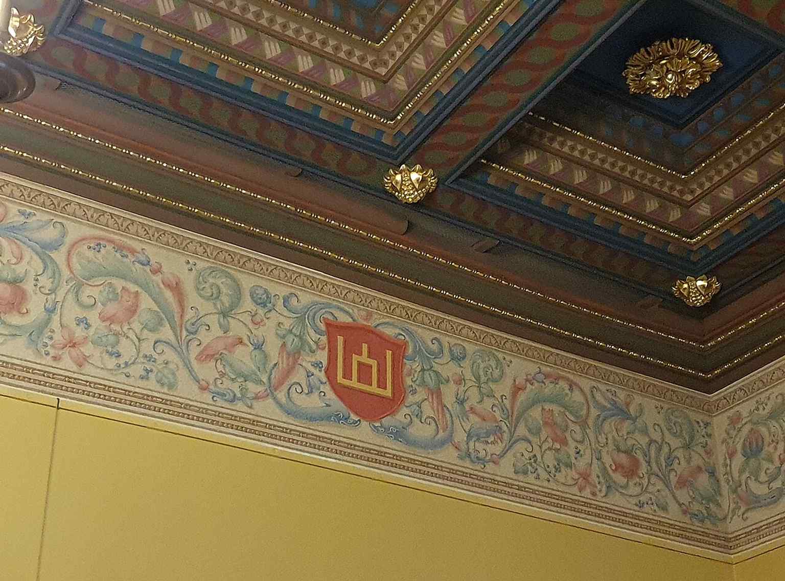 A wall with the Columns of Gediminas, a dynastic symbol tied to Lithuanian rulers and the palace’s historic identity.