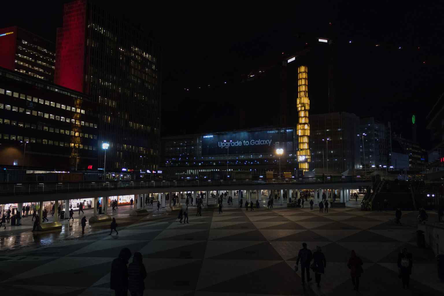 A striking night view of Sergels torg, where the glass obelisk and surrounding buildings are illuminated, creating a vibrant central hub after dark.