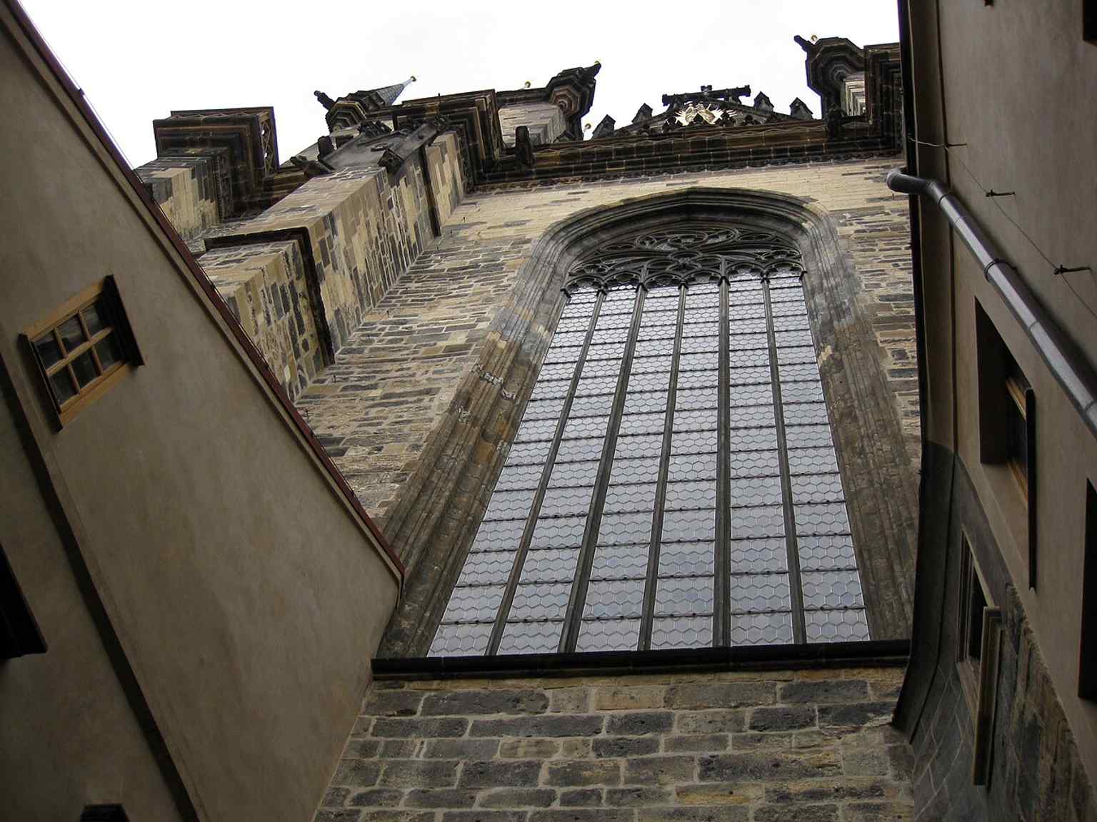 Die beeindruckenden Fenster der Kirche, insbesondere das 28 Meter hohe Ostfenster, zeigen den komplizierten Maßwerkstil, der für das renommierte Werk von Peter Parler charakteristisch ist.
