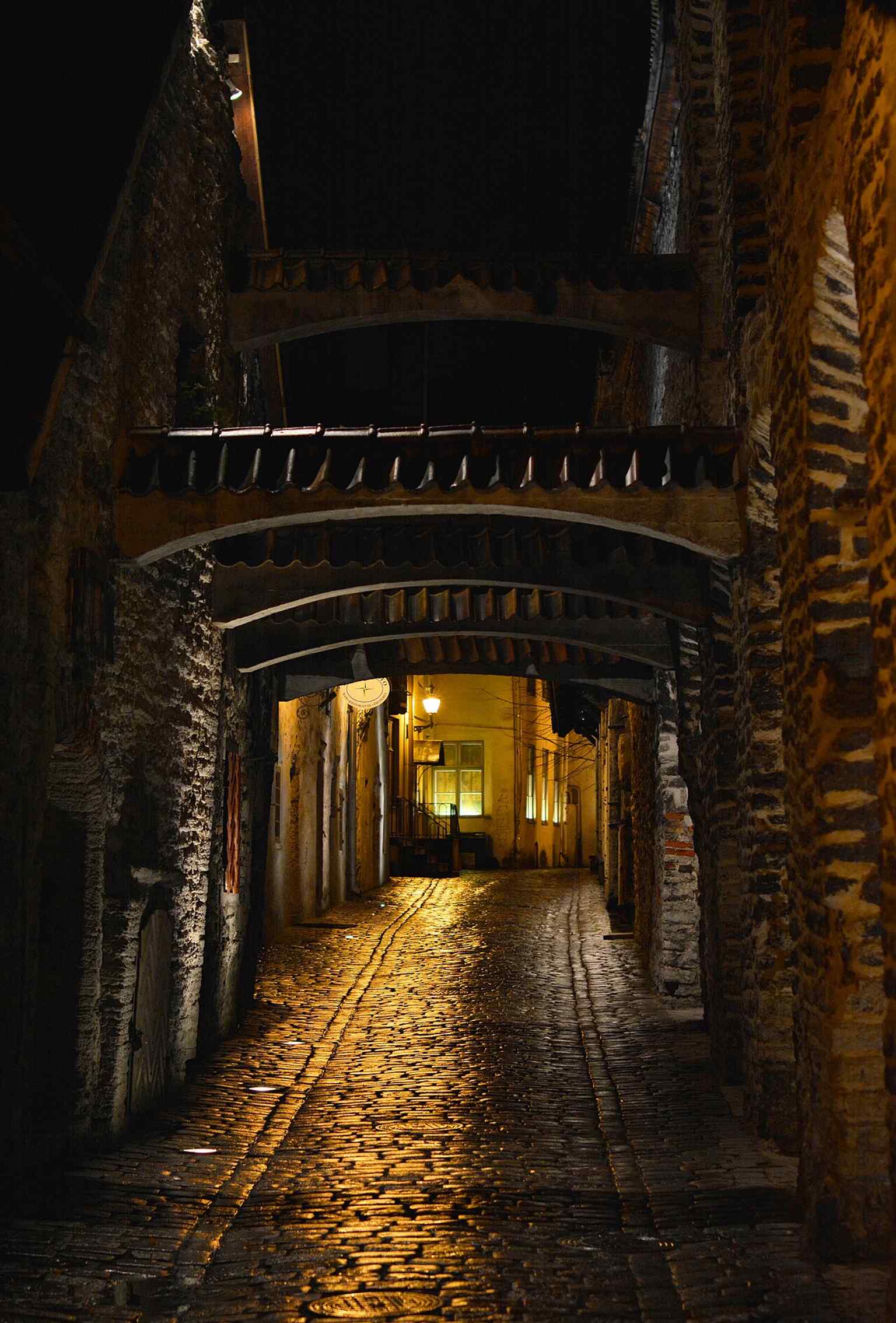 View toward Müürivahe Street at the far end of the passage, showing how this narrow old town corridor opens back onto the city.
