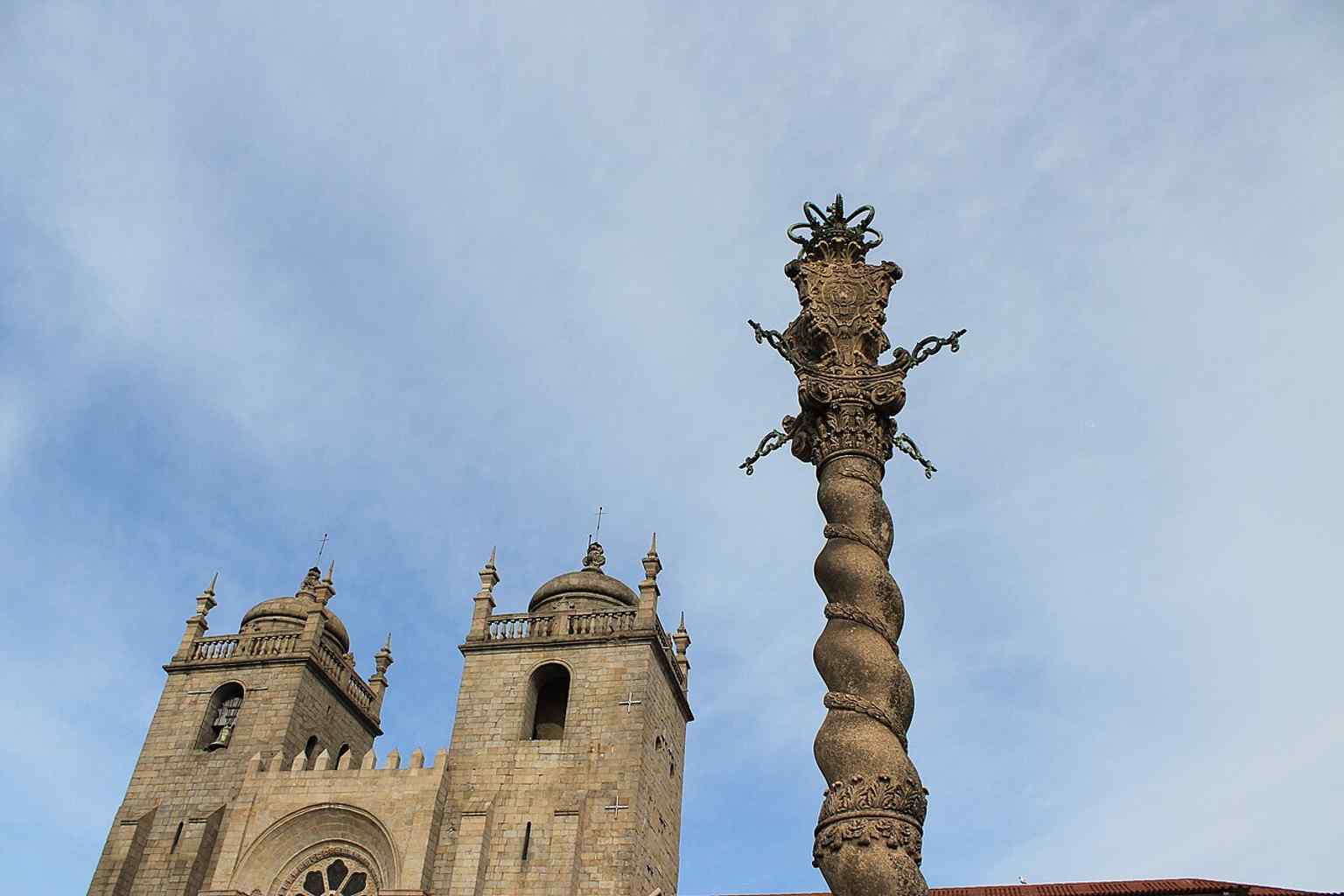 A wider exterior view that helps place the cathedral in the city and shows its heavy Romanesque massing.