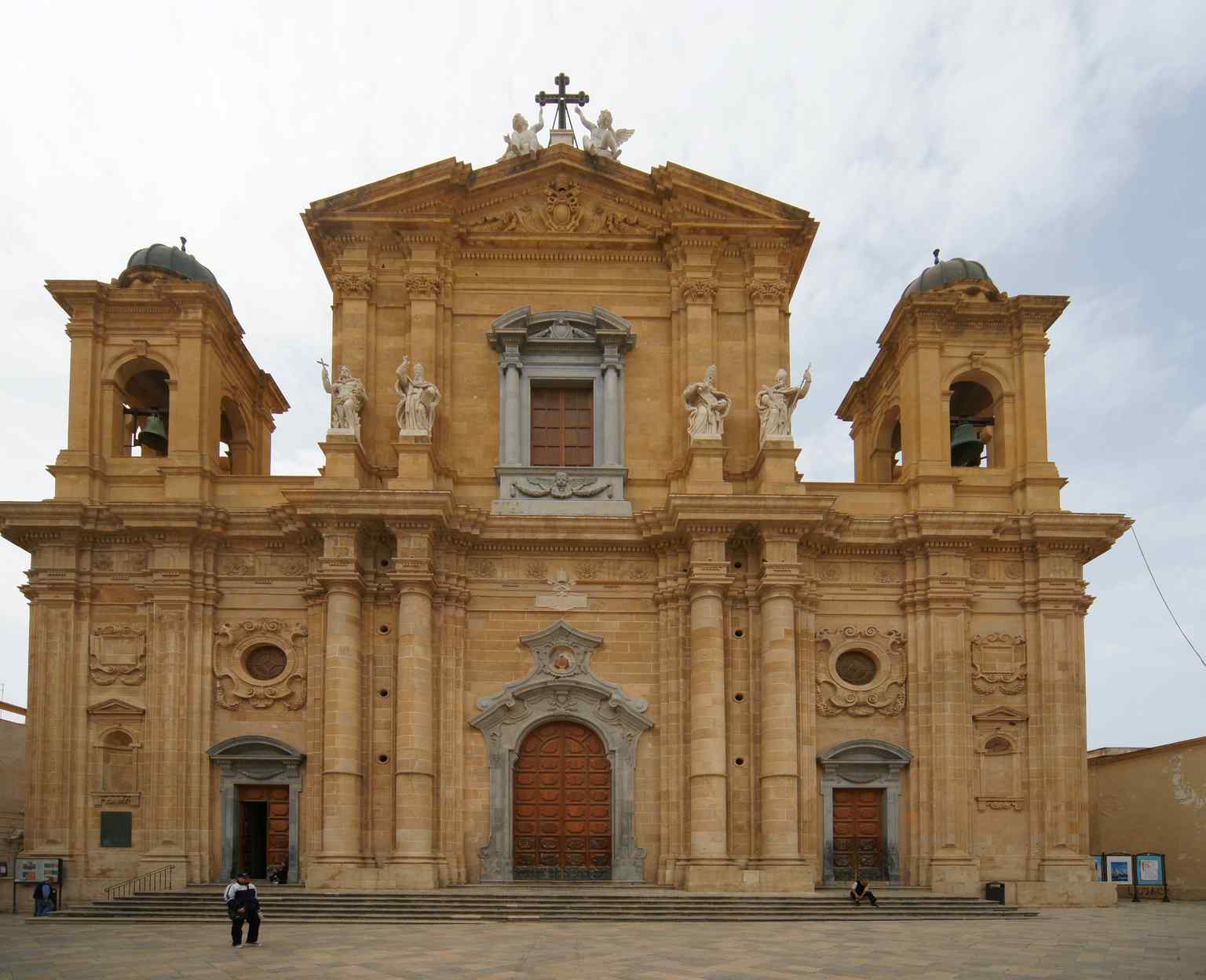 The Mother Church, also known as the Cathedral of Marsala, stands prominently in Piazza della Repubblica, showcasing its Baroque facade with the upper part and bell tower completed a century later in Barocchetto style.