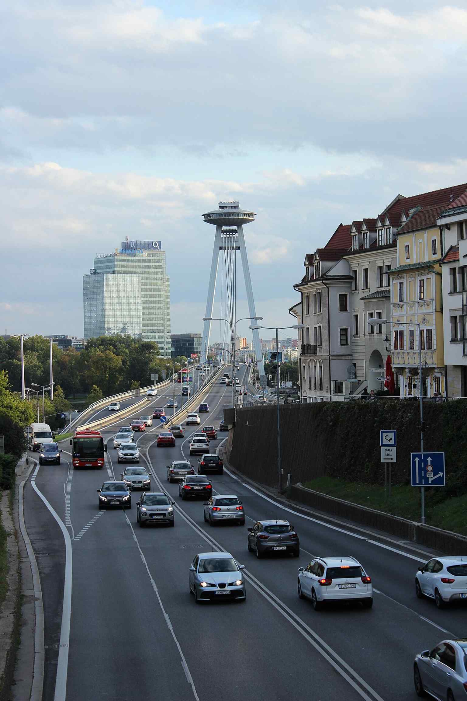 SNP Bridge rising behind Staromestská Street, a good urban context shot that shows how the bridge ties the city center to the river crossing.