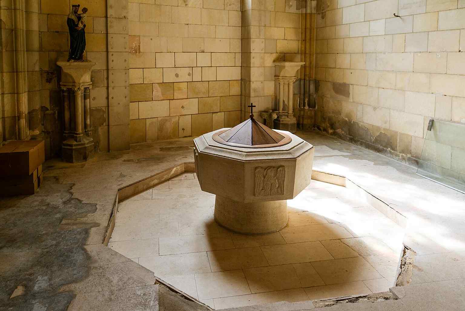 The baptismal fonts in the tower base, matching the source’s description of the clocher’s ground floor as the baptismal space.