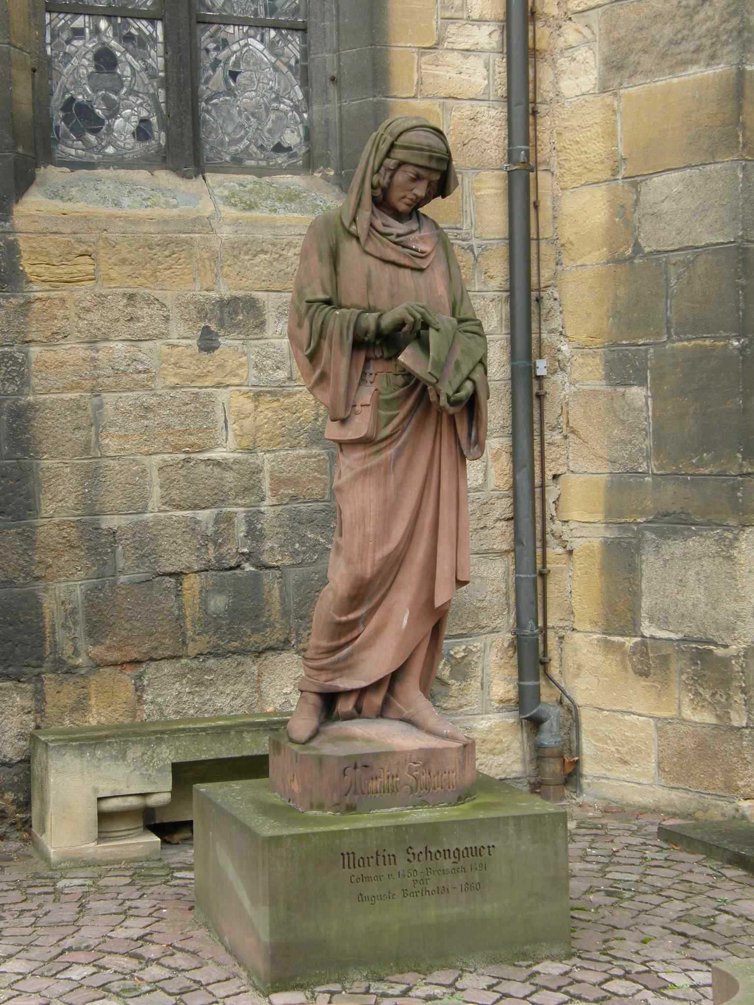 The pink sandstone statue of Martin Schongauer outside the Unterlinden Museum, standing as a quiet testament to medieval art, captured in 2008.