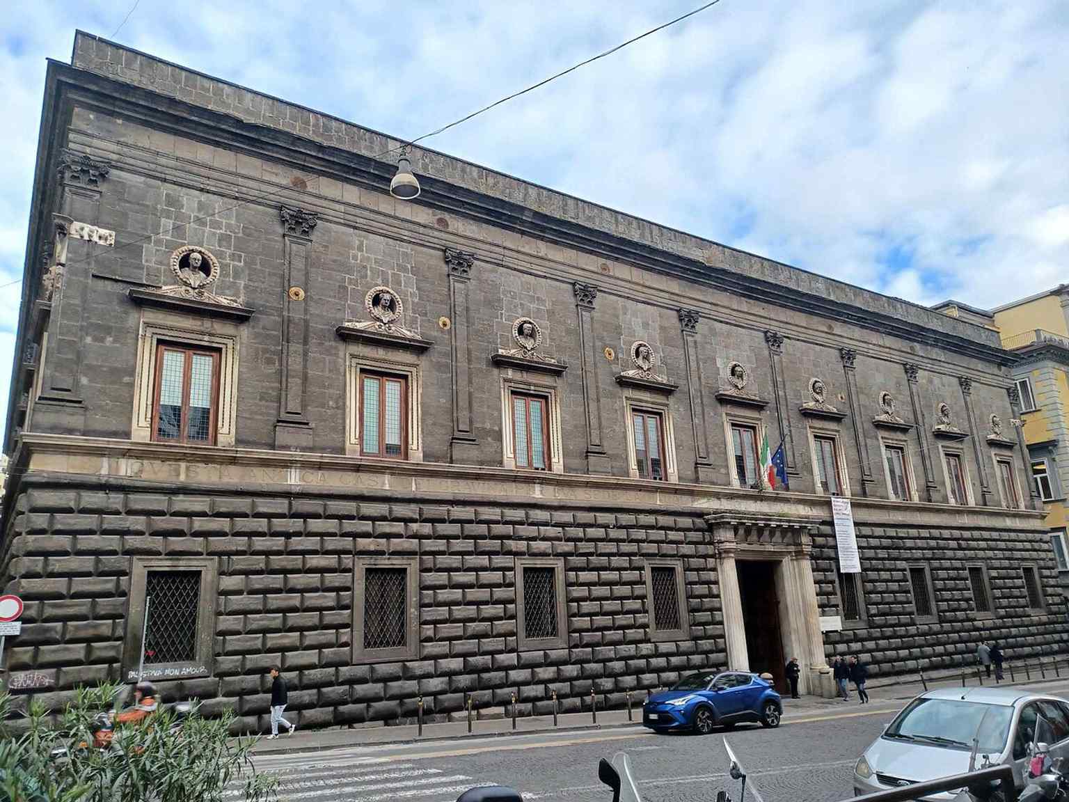 This image captures the elegant Renaissance exterior of Palazzo Orsini di Gravina, showcasing the original cushion rustication and the roundels with Orsini busts by Vittorio Ghiberti, many of which are 19th-century copies of the lost originals.