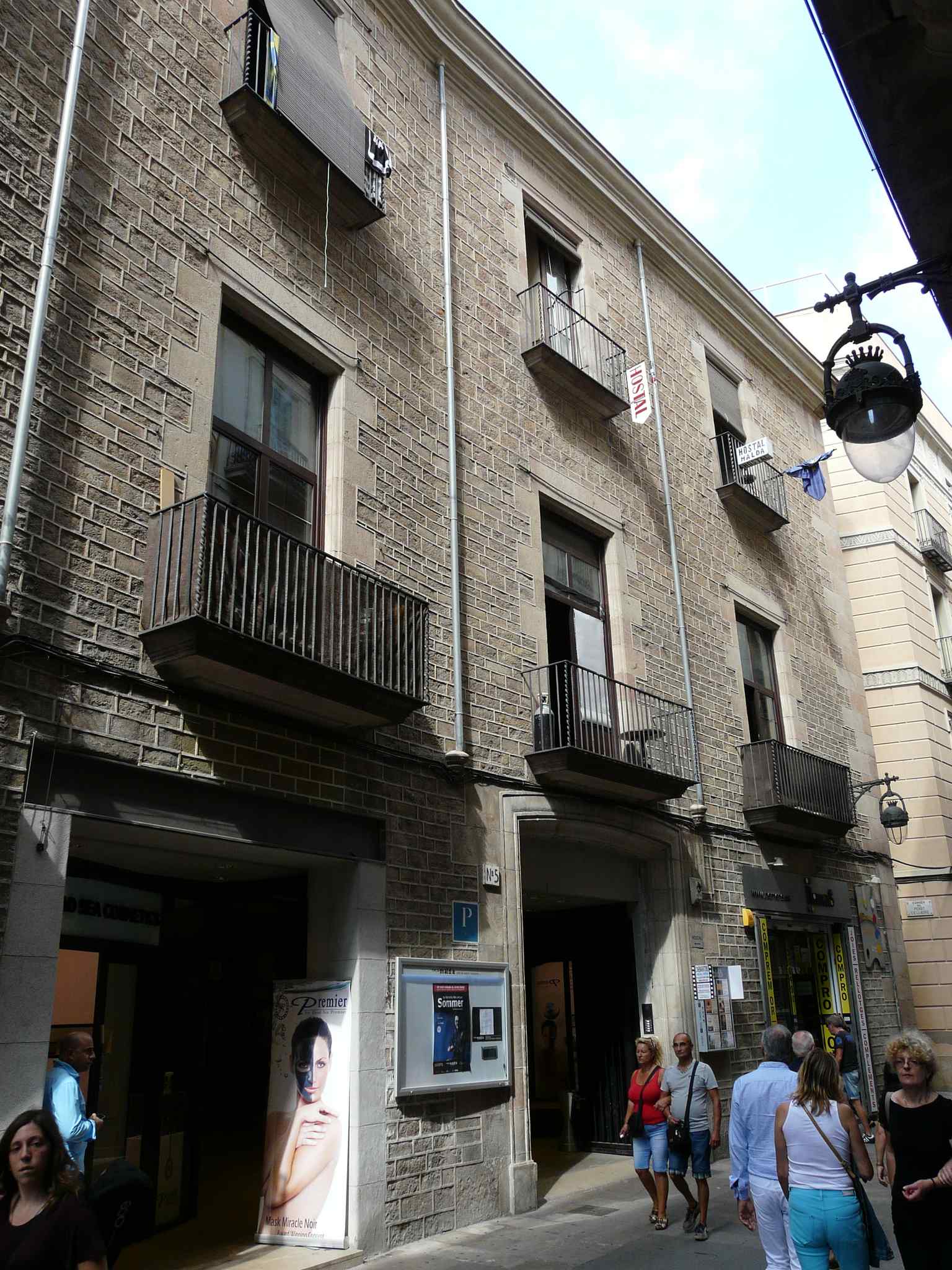 The main facade of Palau Maldà on Carrer del Pi, featuring the large stone arch that serves as the entrance to the historic Galerías Maldà, originally the palace's stables.