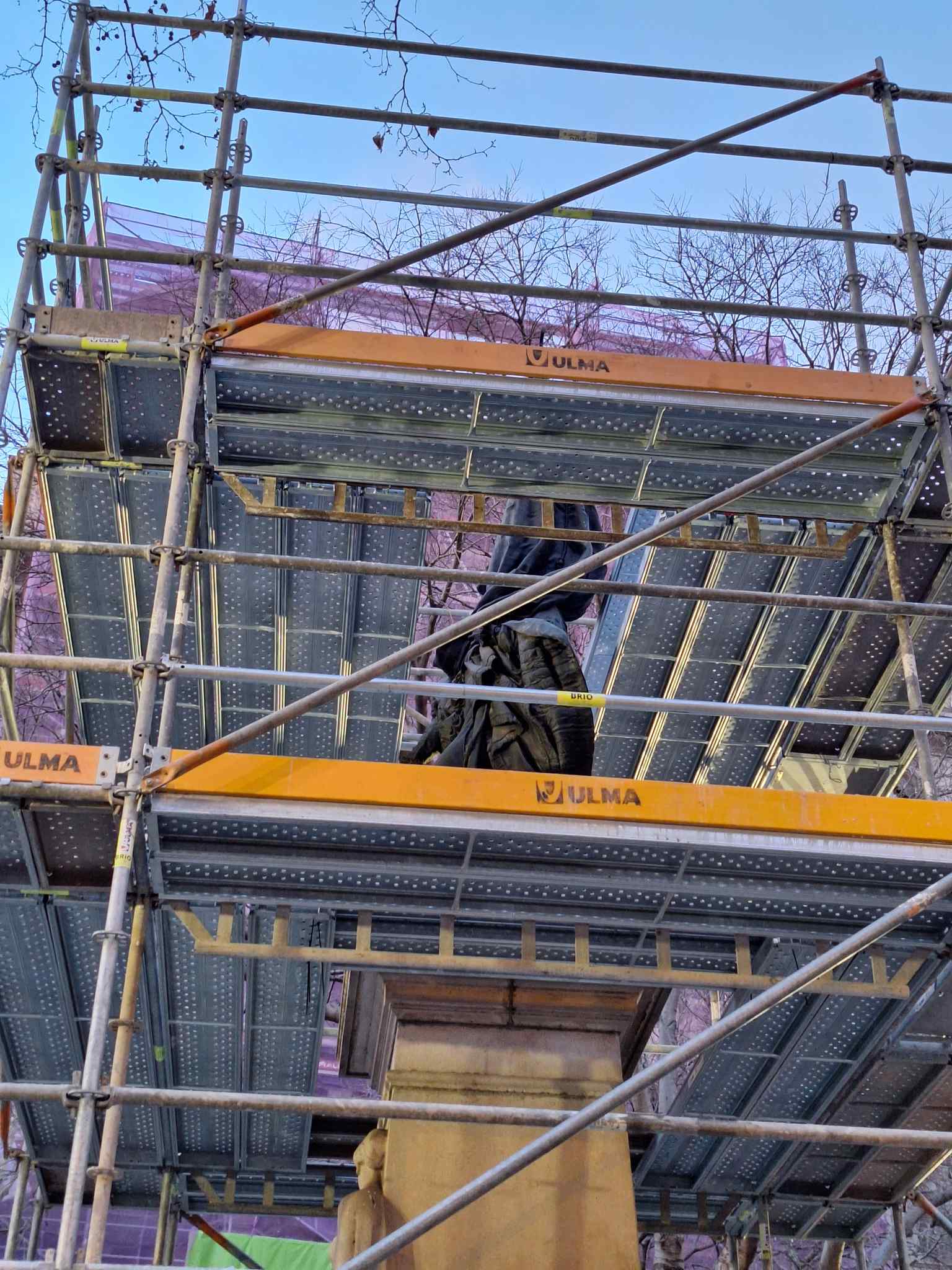 A detail view of the Rafael Casanova statue during its 2024 restoration, highlighting Rossend Nobas's depiction of a wounded Casanova heroically holding the Santa Eulalia flag, a symbol used only in moments of extreme gravity for Barcelona.